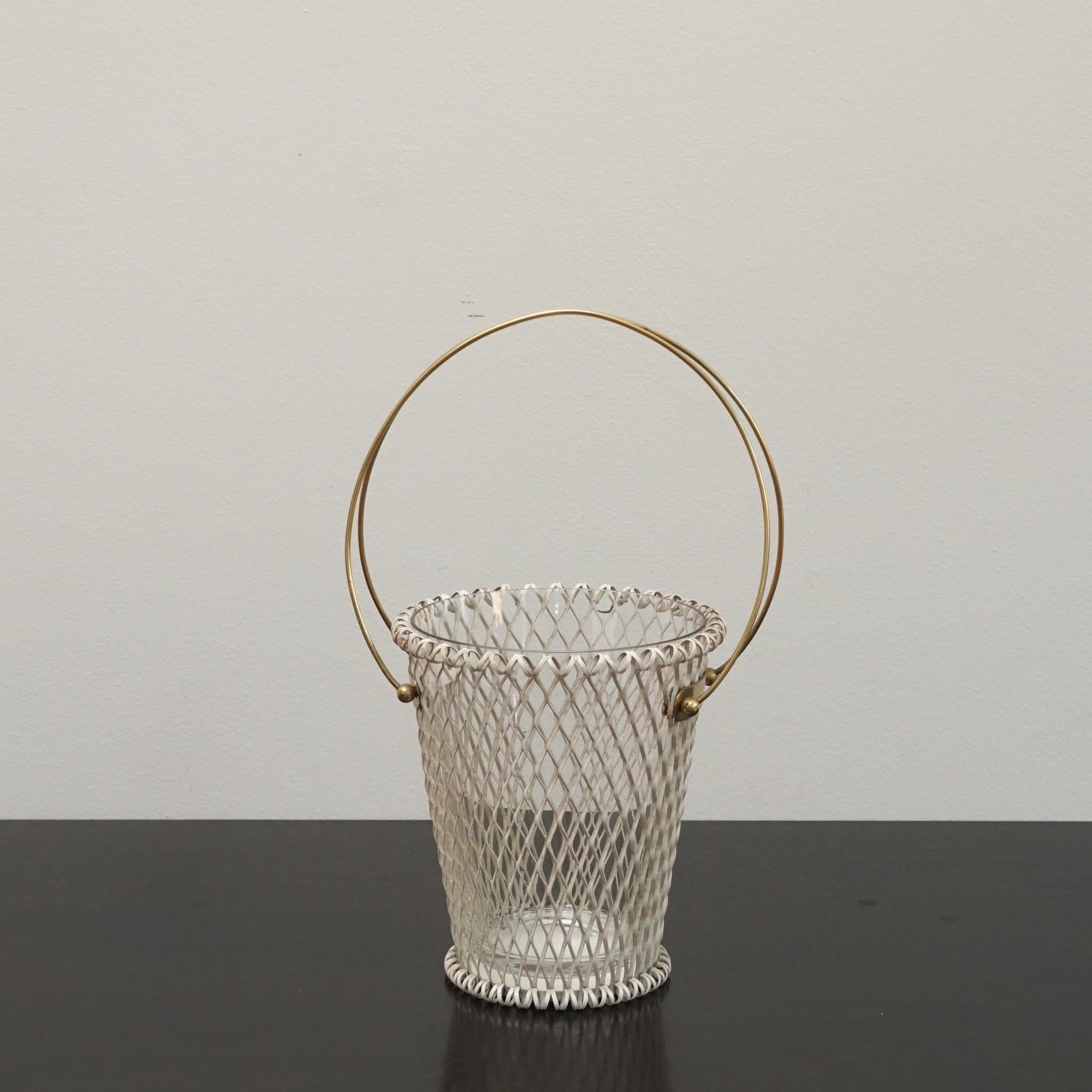 Questo cesto da fiori modernista in stile Mategot è stato prodotto in Francia negli anni Sessanta.  Venduto in set da due, ogni cesto portafiori è realizzato in metallo laccato bianco con una maniglia rotonda in ottone nella parte superiore e un