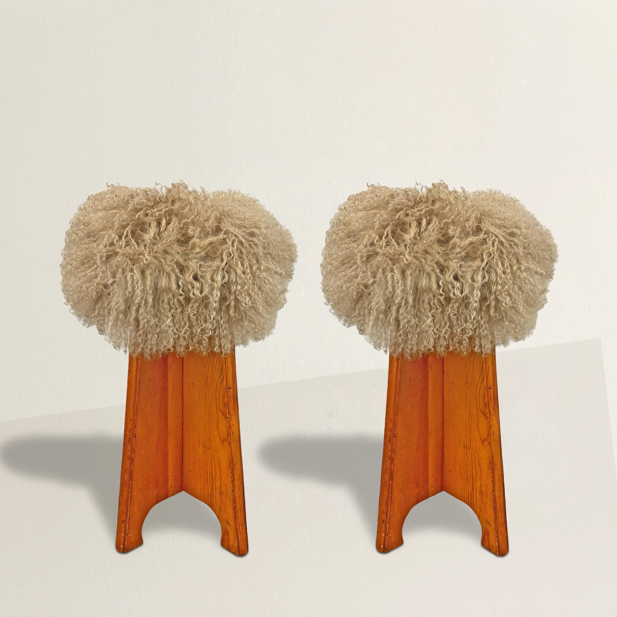 This playful pair of mid-20th century American pine stools packs a modernist punch with their stylish X bases, each side ending in a chic short stylized hoof foot. Newly upholstered in luxurious curly Mongolian lamb, these stools bring a fun yet