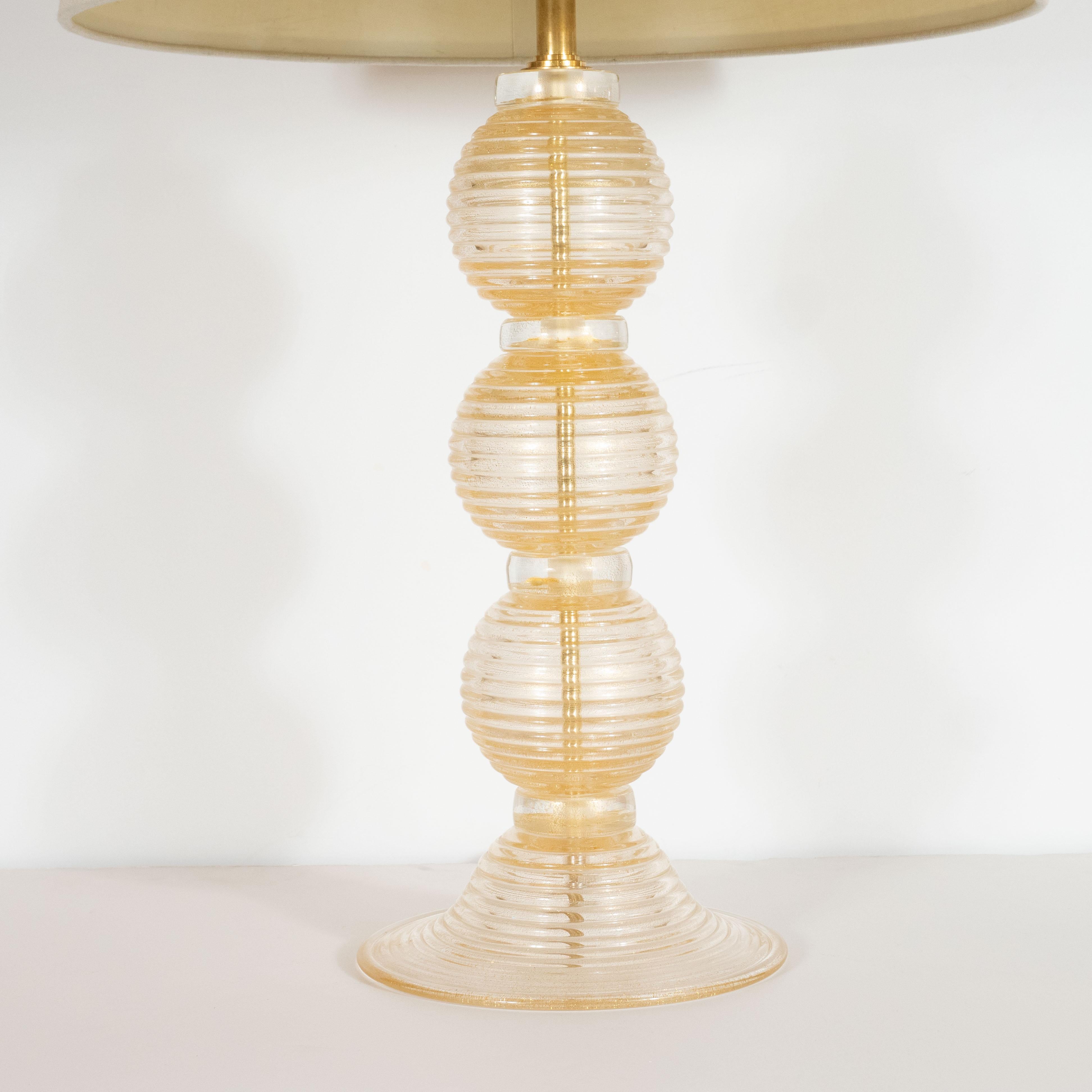 This dramatic pair of table lamps were realized in Murano, Italy the islands off the coast of Venice that have been renowned for centuries for their superlative glass production. They feature three orbital forms with horizontal striations executed