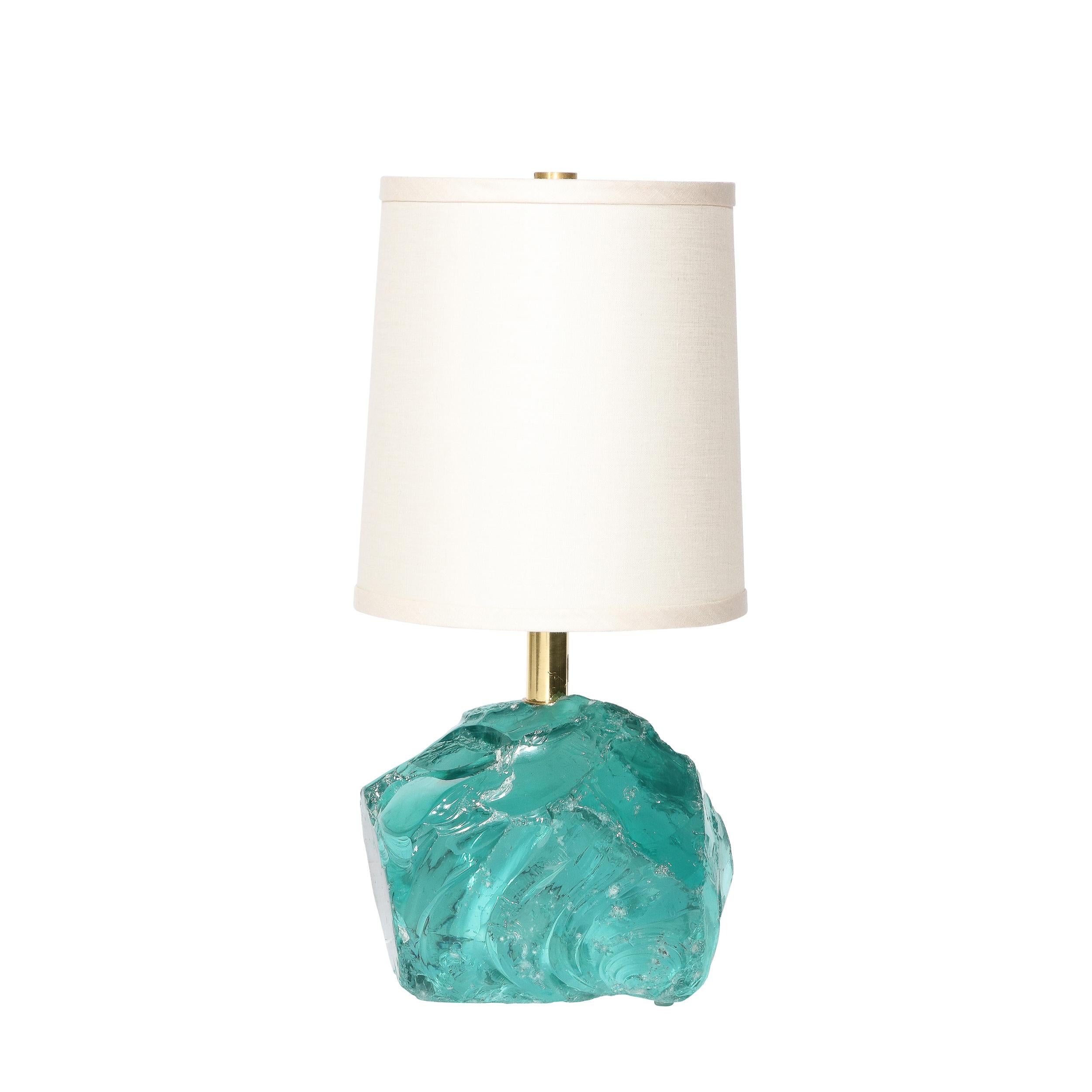 This exquisite pair of handcut aquamarine glass table lamps were hand blown in Murano, Italy- the island off the coast of Venice renowned for centuries for its superlative glass production- during the 21st century. Inspired by the work of Jean