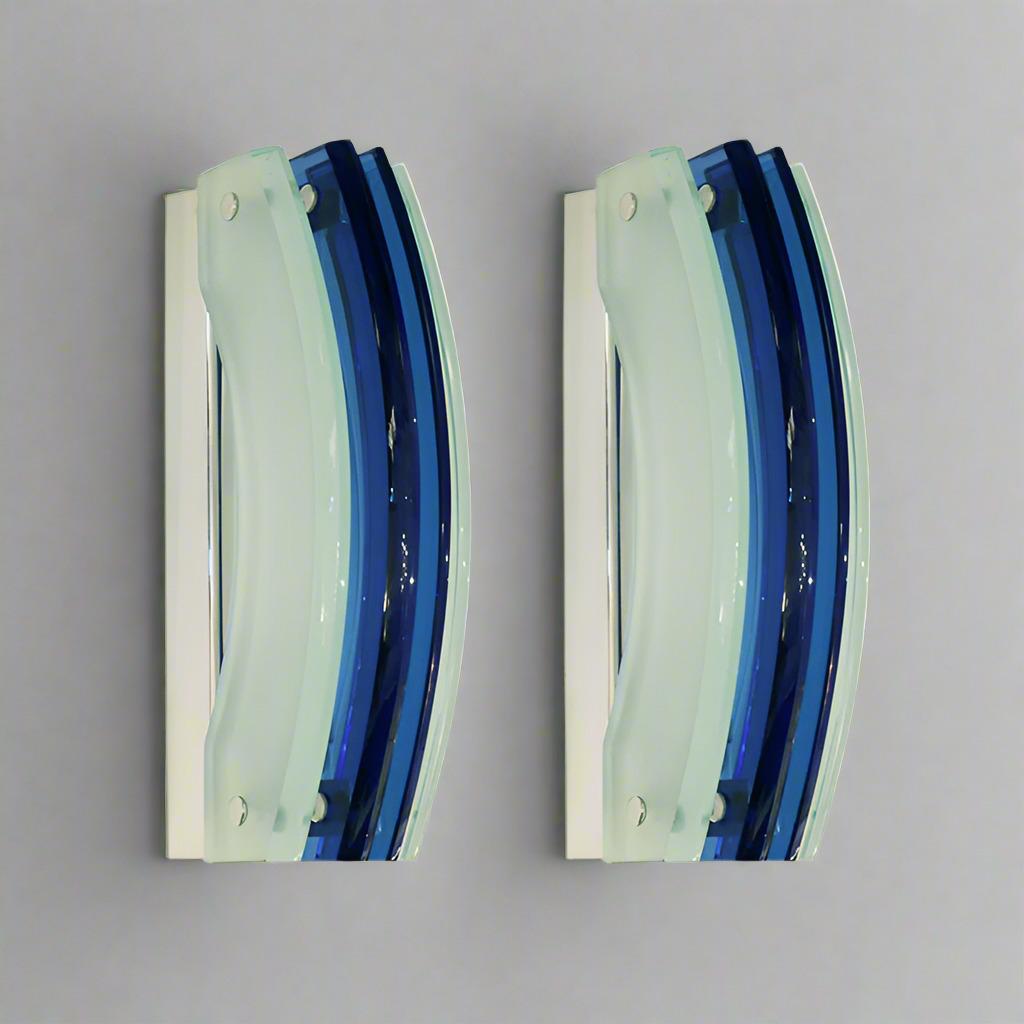 Paire d'appliques en verre d'art italien moderniste par Veca. 
Panneaux incurvés en verre bleu et dépoli montés sur une base en métal chromé. 
Une seule douille à base Edison dans chaque applique.