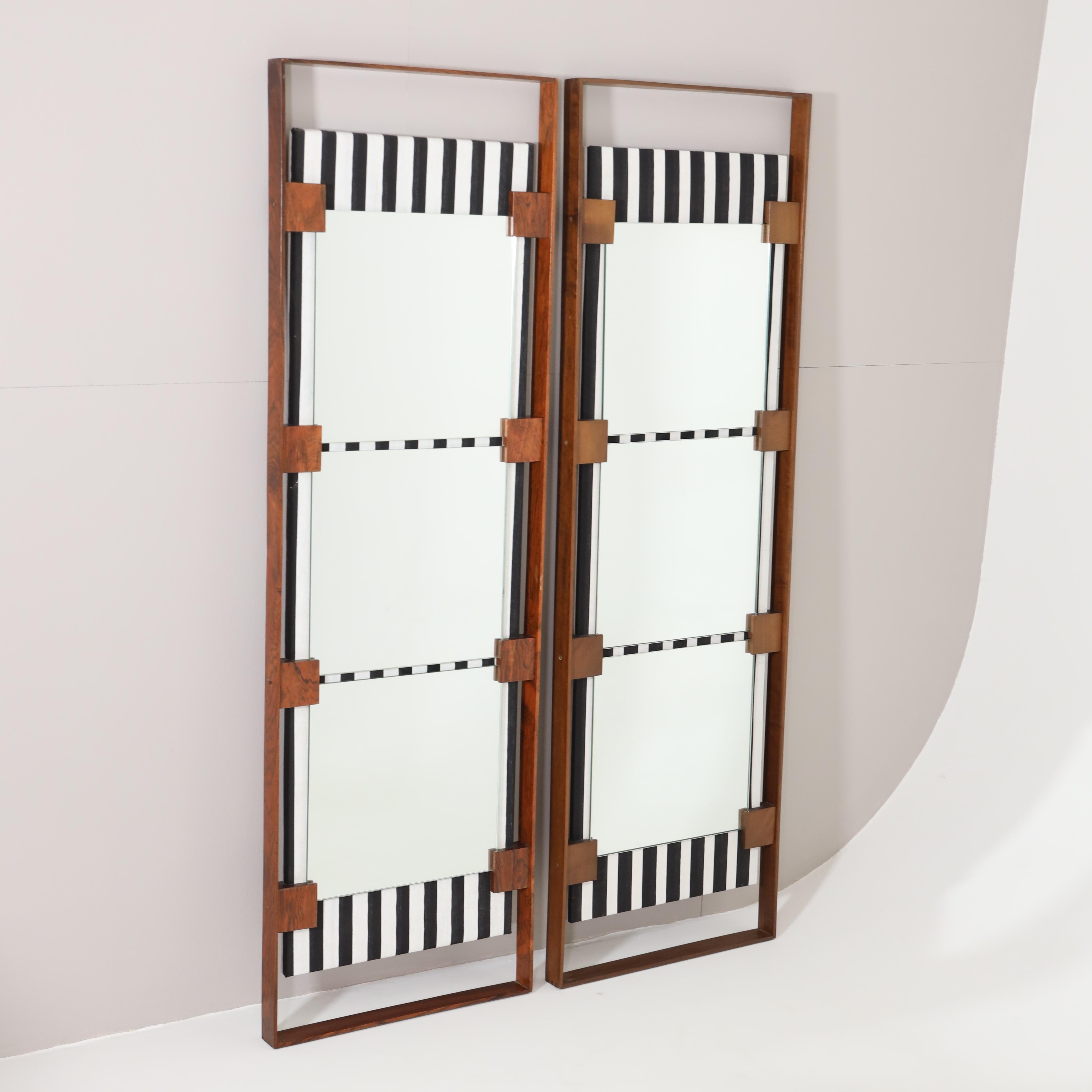 A pair of tall Italian Modern mirrors.
Walnut with black and white vertically striped fabric panel 
with three mirrors mounted on top of the panel.