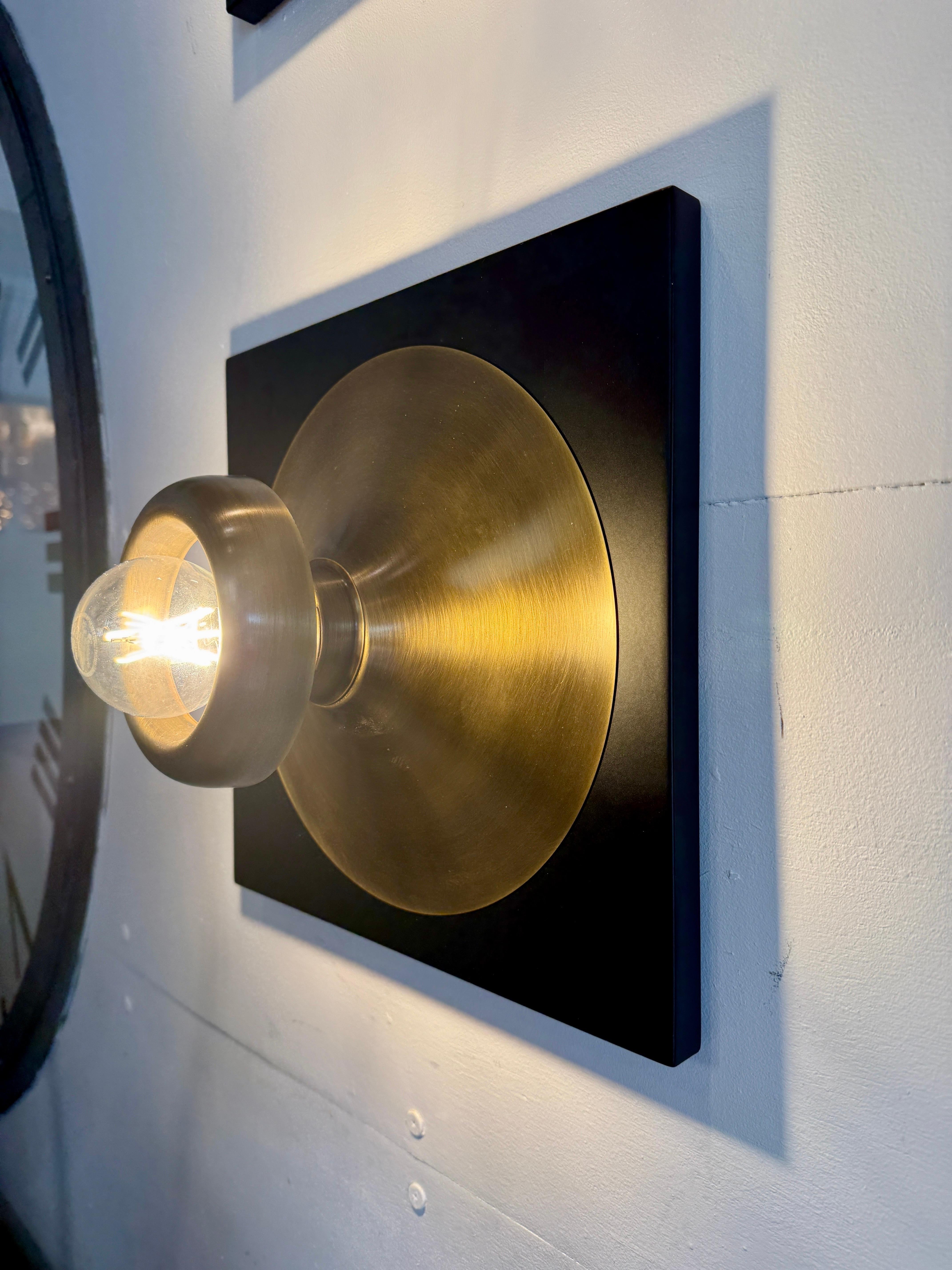 Fully restored to their original beauty, these square painted metal wall appliques with brass diffusers which show the exposed light bulb.  Wonderfully modern for their time (1960's).