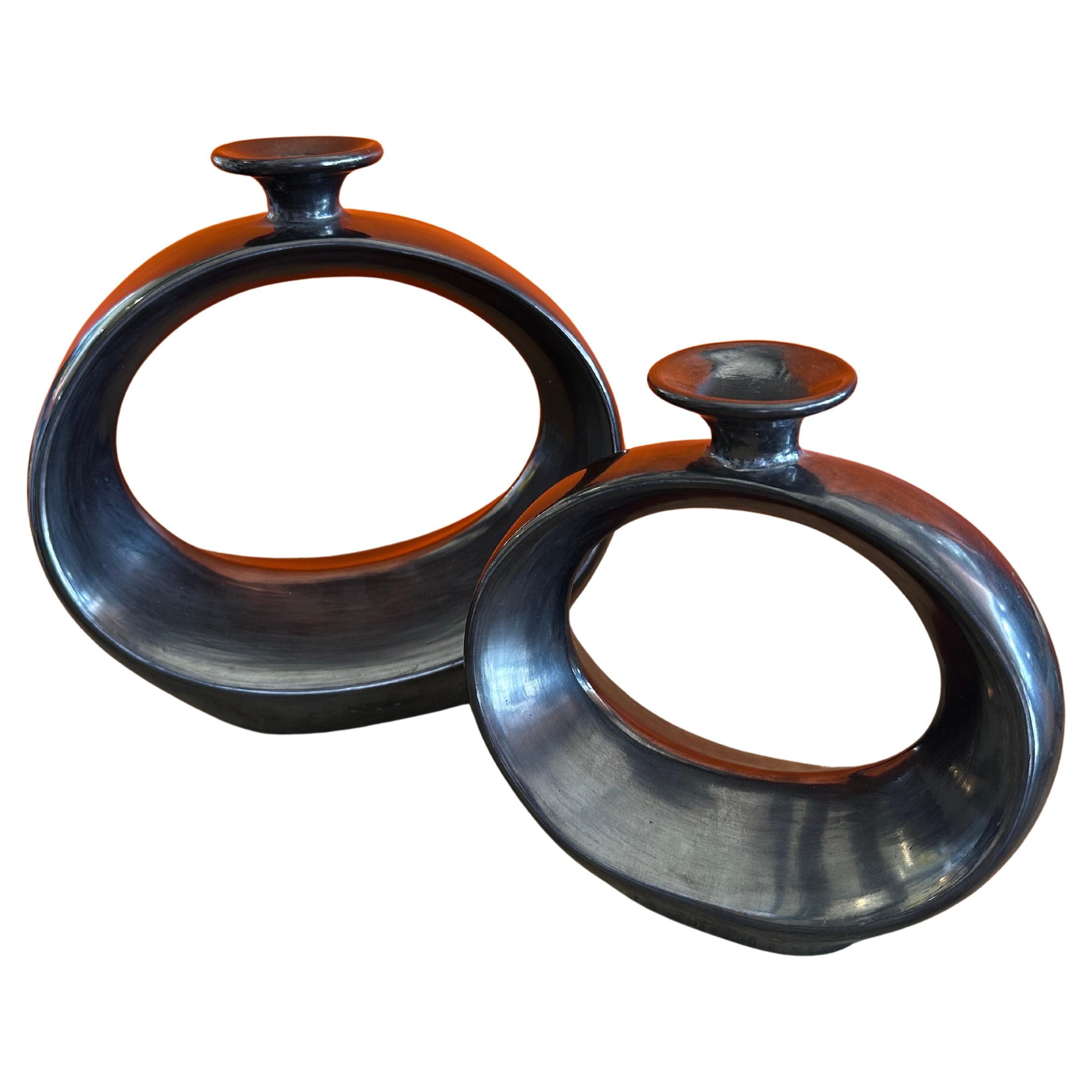 A very cool pair of modernist MCM black barro negro pottery vases by Doña Rosa of Oaxaca, Mexico, circa 1970s. The large vase stands approximately 11.25