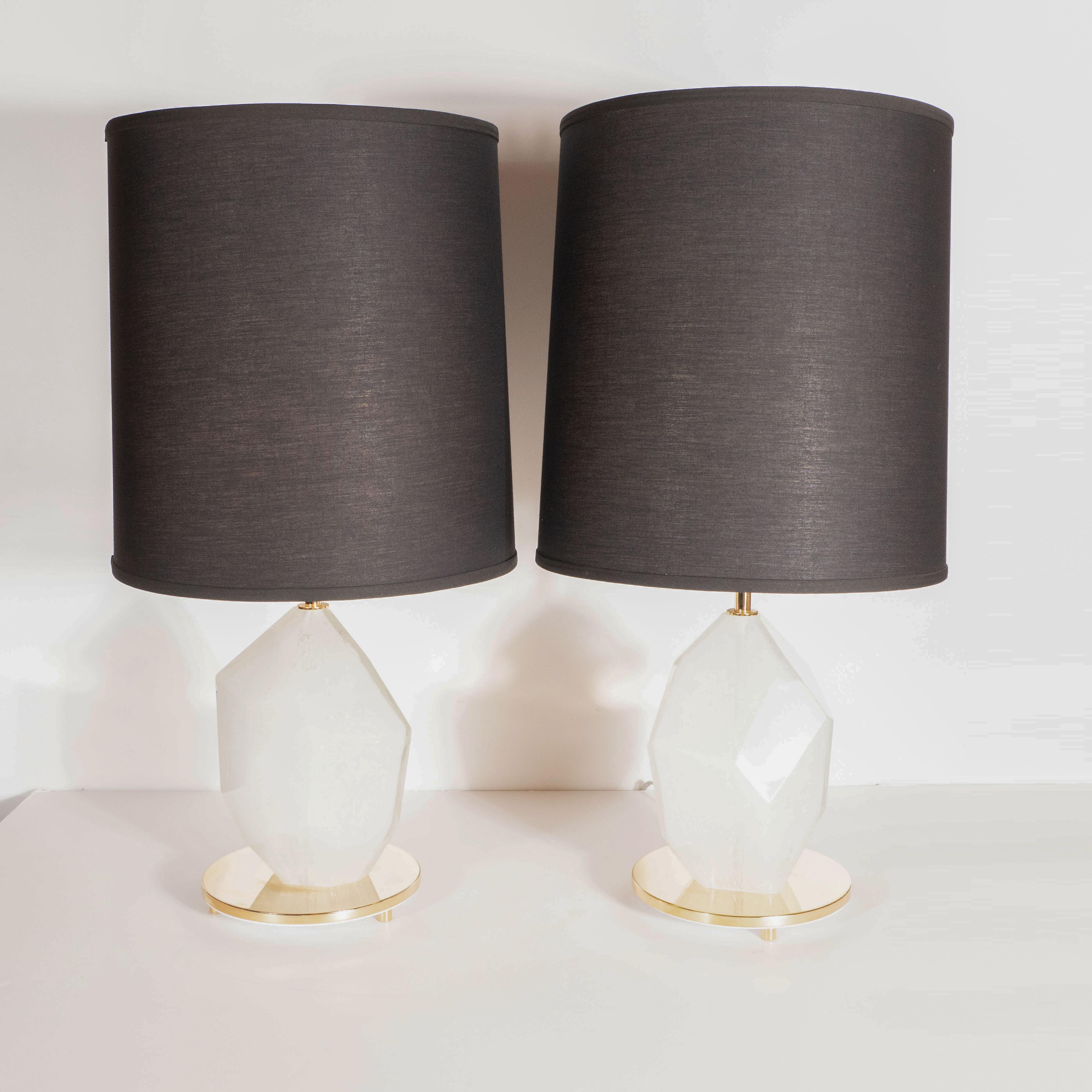 This stunning and dramatic pair of modernist table lamps were handblown in Murano, Italy- the islands off the coast of Venice renowned for centuries for their superlative glass production. They offer faceted white glass bodies- resembling exquisite