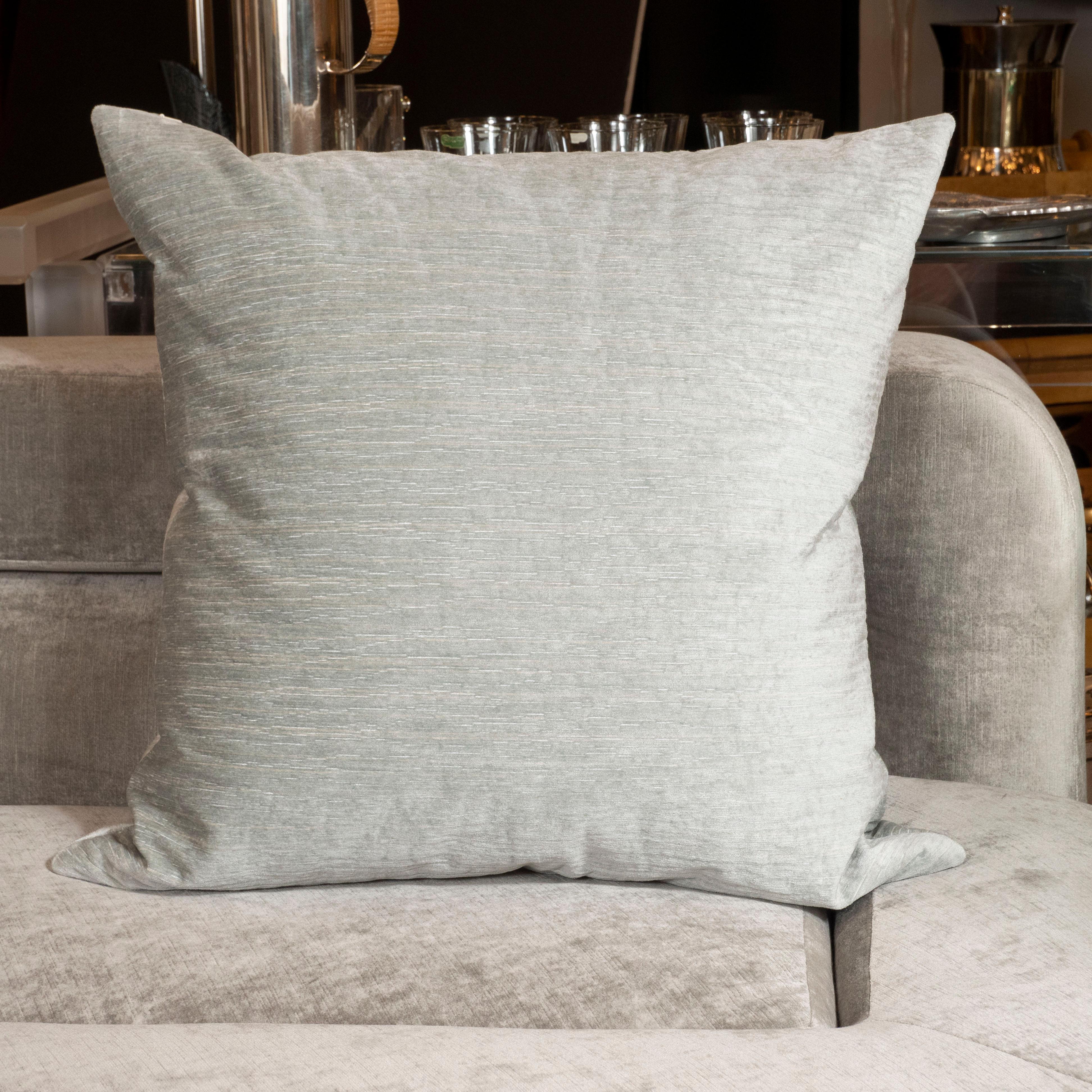 This gorgeous pair of modernist pillows were realized in the United States during the 21st century. They feature square bodies that covered in a soft striated sea foam velvet. With their refined palate and austere organic texture, they would be a