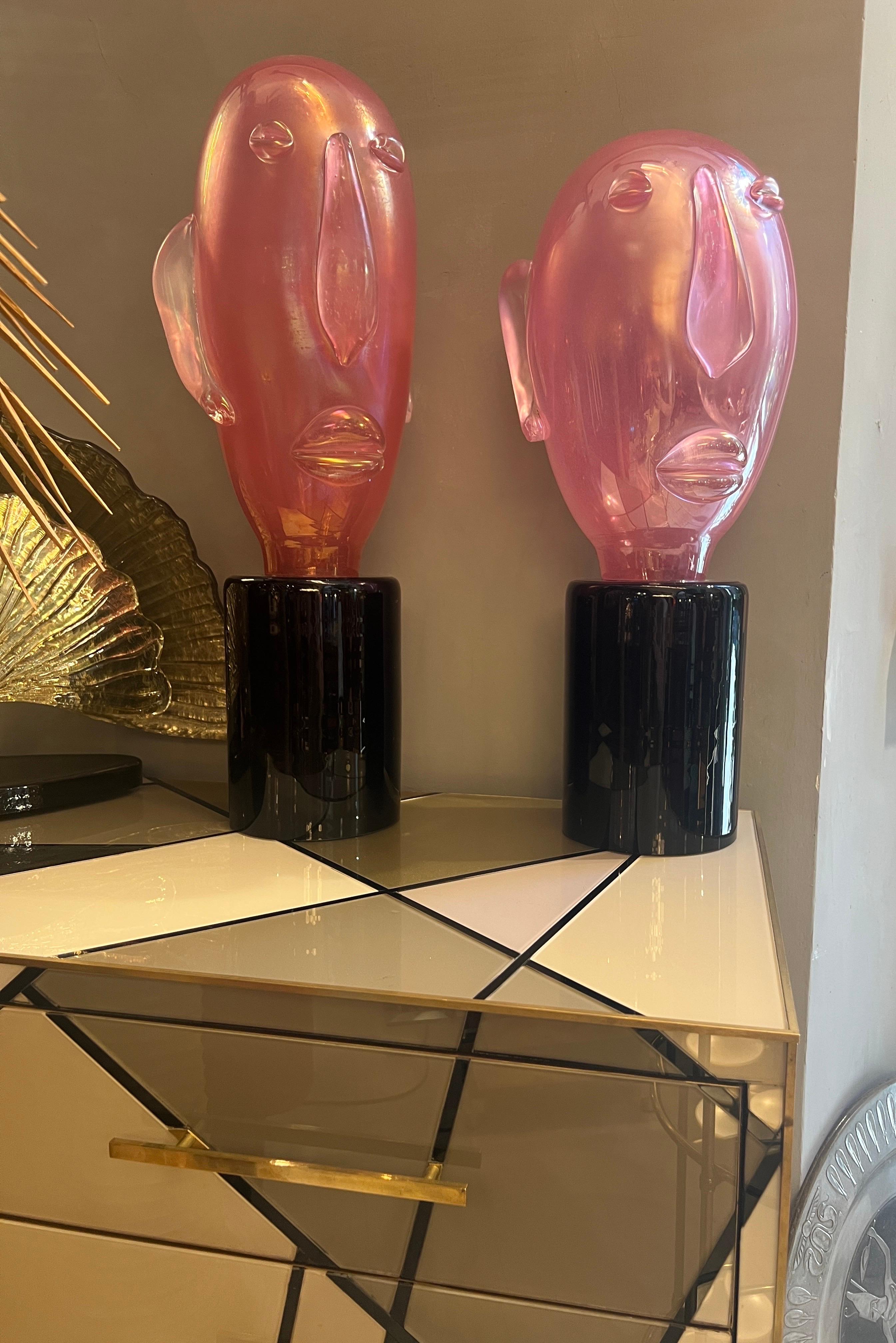 Coppia di sculture in vetro di Murano rosa in stile modernista con un design a forma di testa ispirato a Picasso, montate su una base cilindrica in vetro di Murano nero. La testa allungata è realizzata in rosa  Vetro di Murano con un leggero effetto