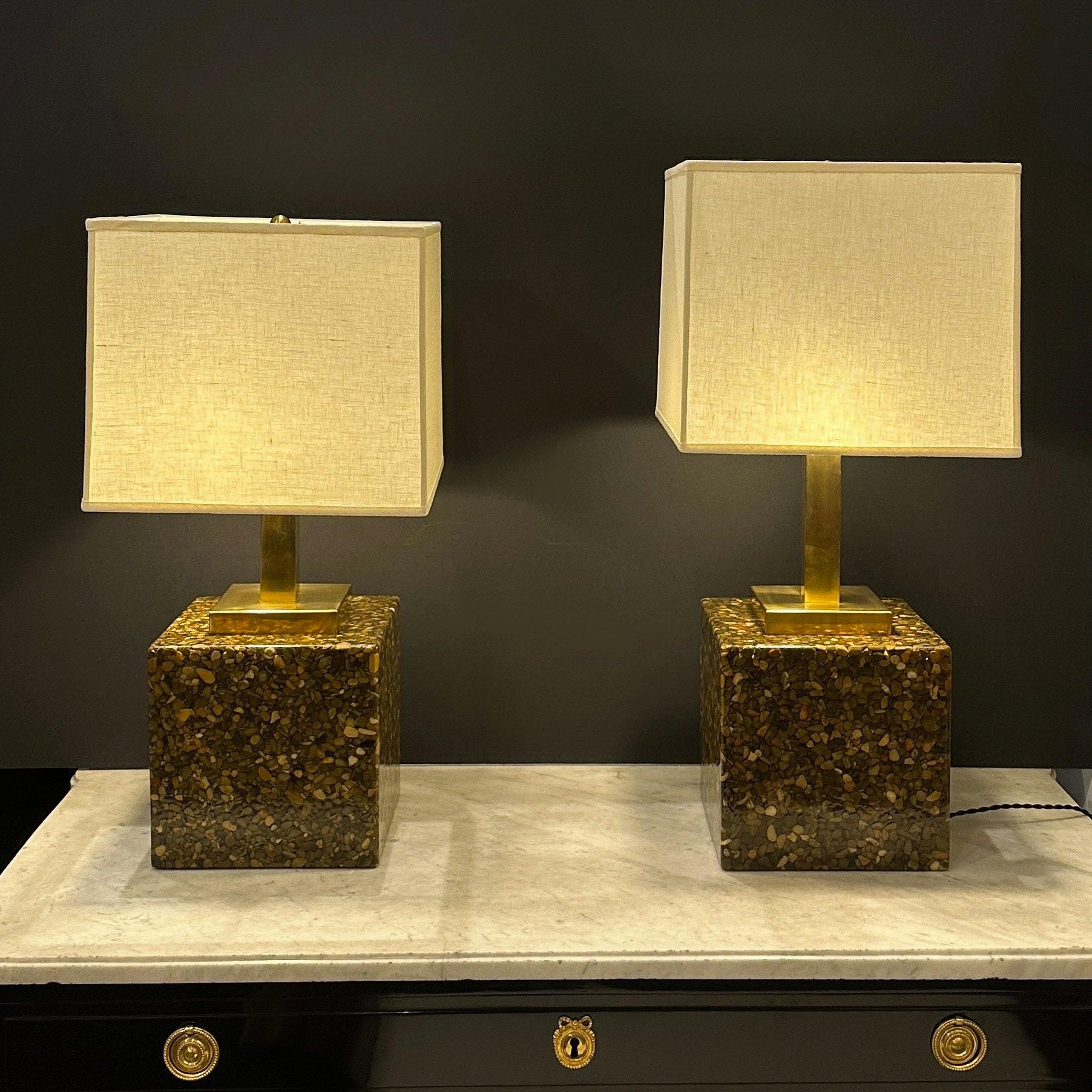A pair of Modernist resin and stone table lamps. 
Clear resin over small stones with patinated brass mounts and details.