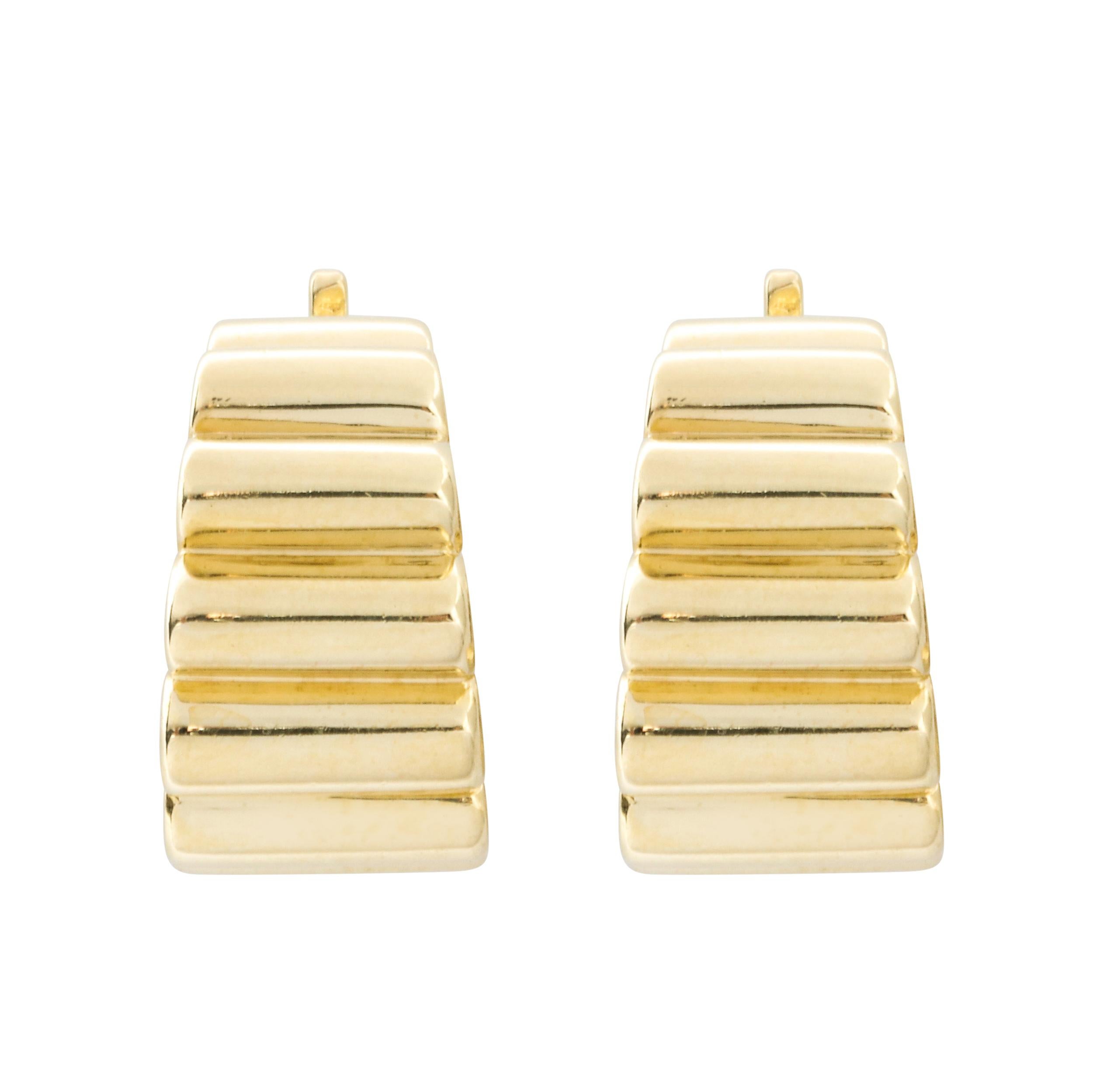 This elegant pair of 14kt yellow gold earrings were realized by Tiffany & Co. one of America's premiere luxury makers of jewelry and other precious objects since 1837. They feature rounded bodies composed of seven adjoined cylindrical forms in