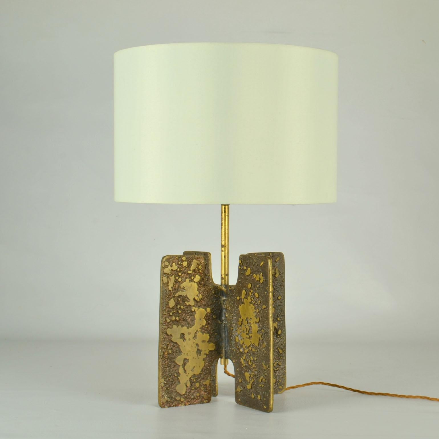 Pair of exceptional cast bronze table lamps in the manner of Jean Michel Frank. The base is simply formed in the X shape of an extruded cross. This demonstrates perfectly balance of minimalist lines and texture. 
The design of the lamps are in the