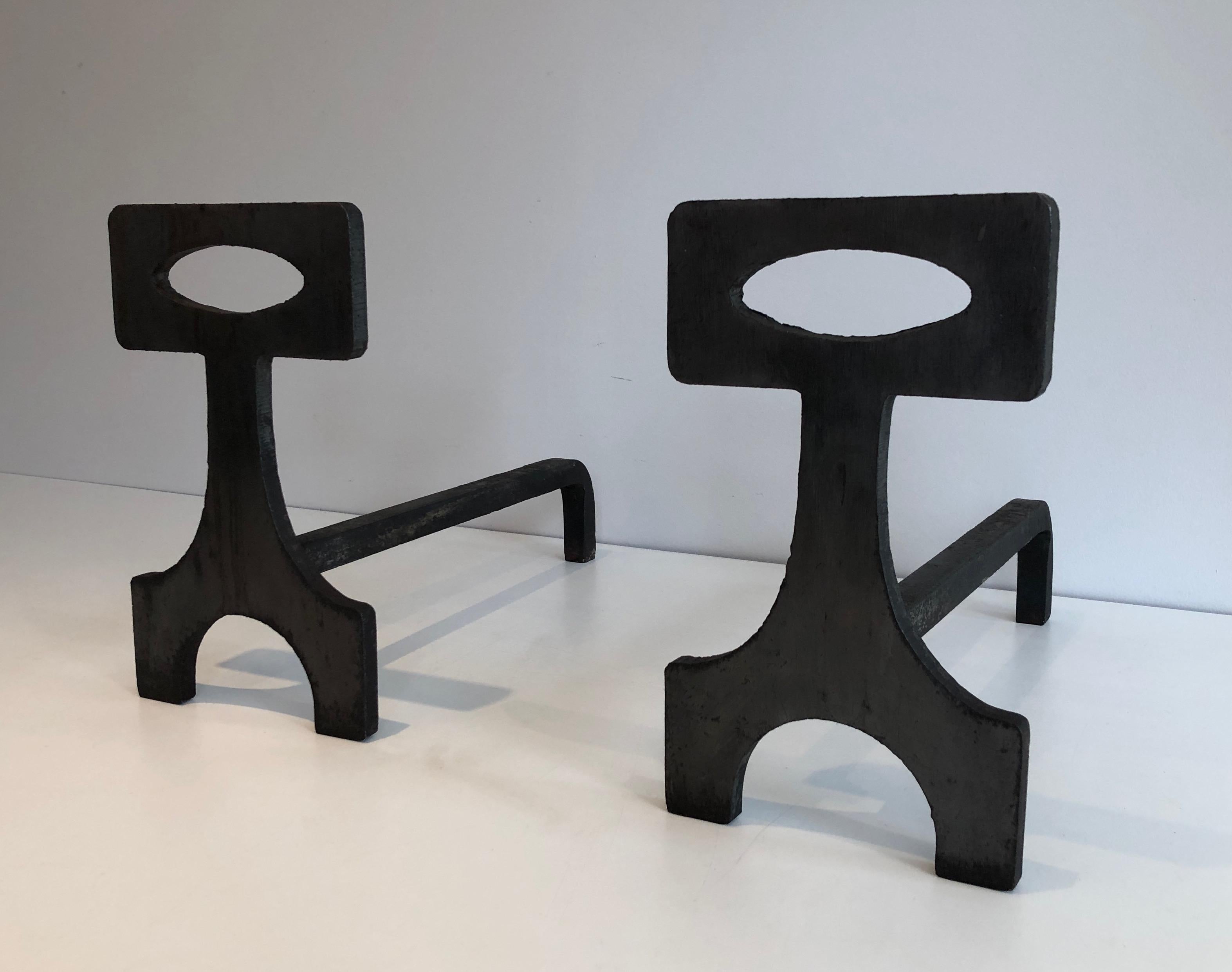 This pair of modernist andirons is made of steel and wrought iron. This is a French work, circa 1970.