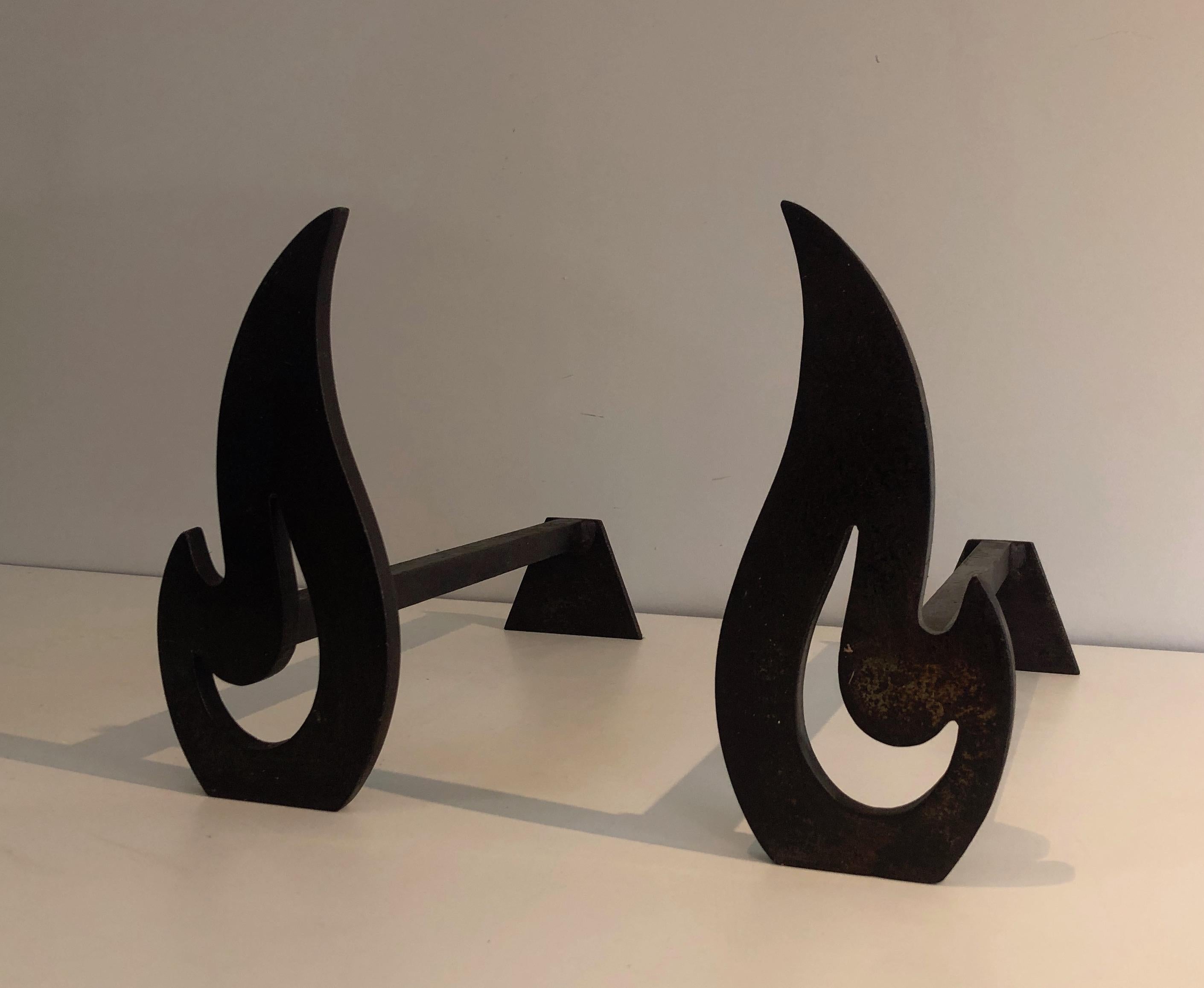This pair of modernist flame andirons is made of steel and wrought iron. This is a French work, circa 1970.