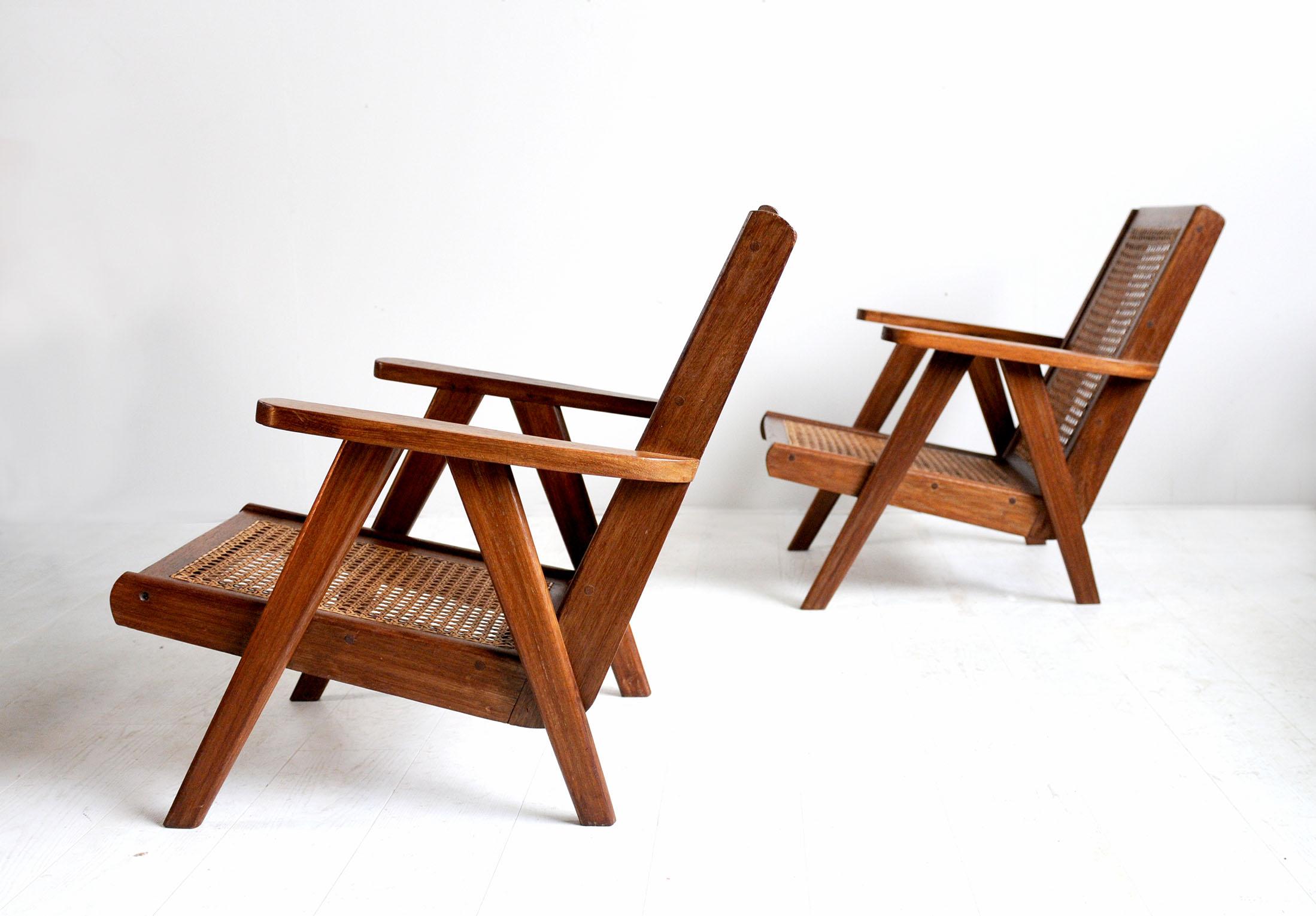 Pair of modernist armchairs in solid teak, cane seat and backrest, Congo, 1950. The boomerang-shaped seat rests on a compass base surmounted by a wide armrest.
Very good condition, cane refurbished.