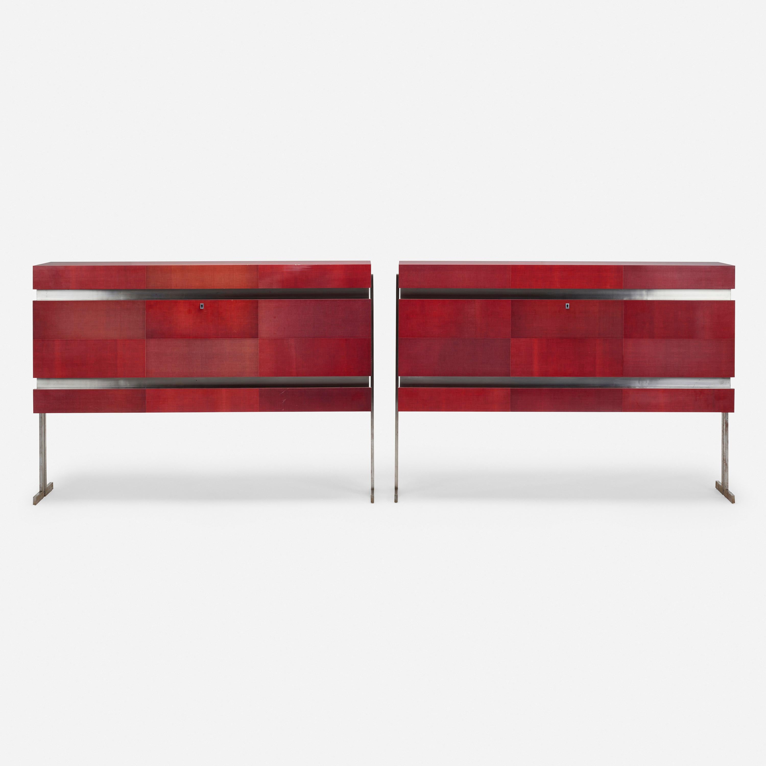 Pair of modernist veneered laminated crimson fabric cabinets by Maxime Old , resting on brushed steel bases.Each cabinet features a flip-top compartment concealing storage above a drop-front door concealing storage with three non-adjustable shelves