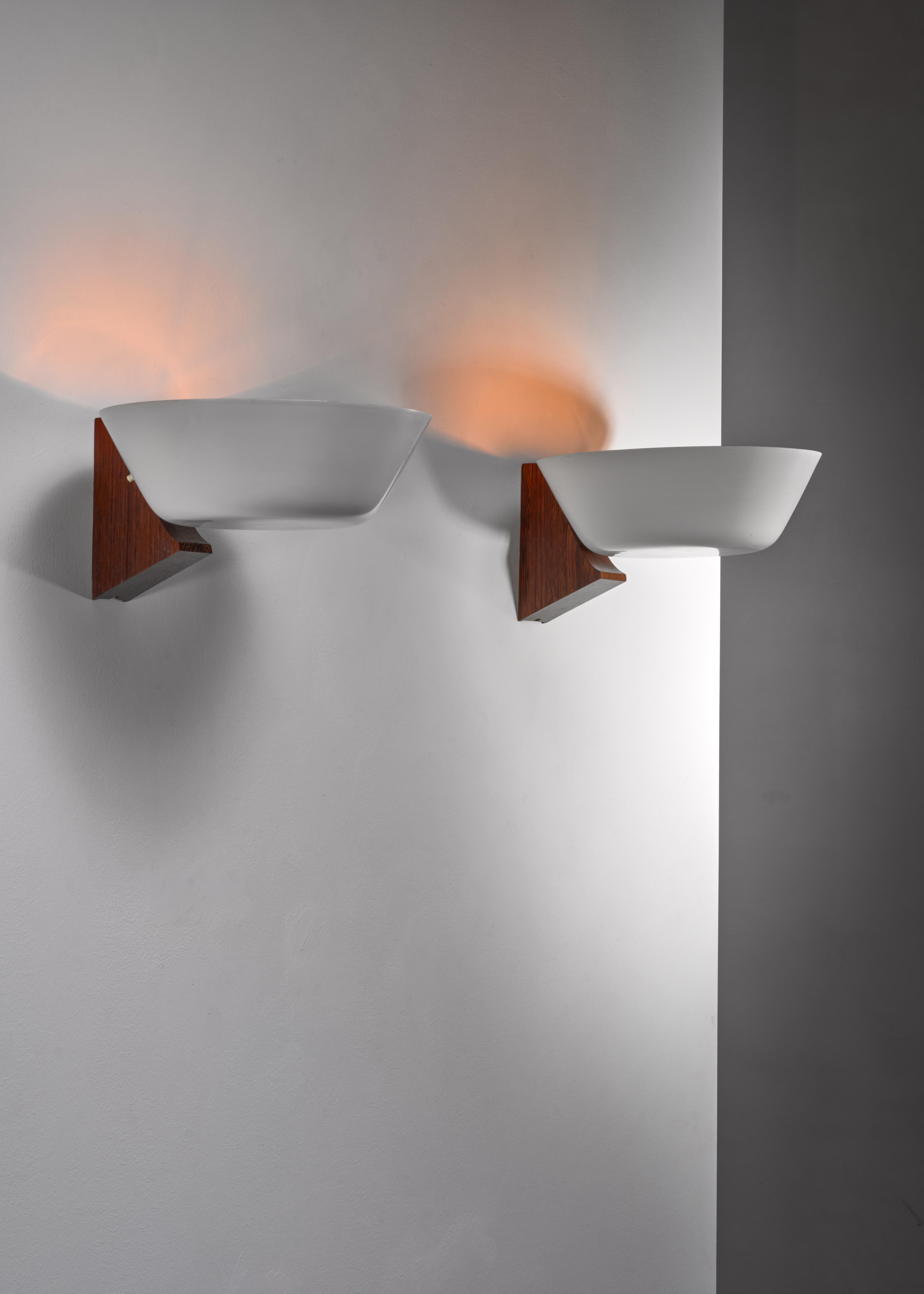 A pair of mid-century wall lamps with a wooden wall-mount and a grey-white lacquered bowl shaped metal shade.