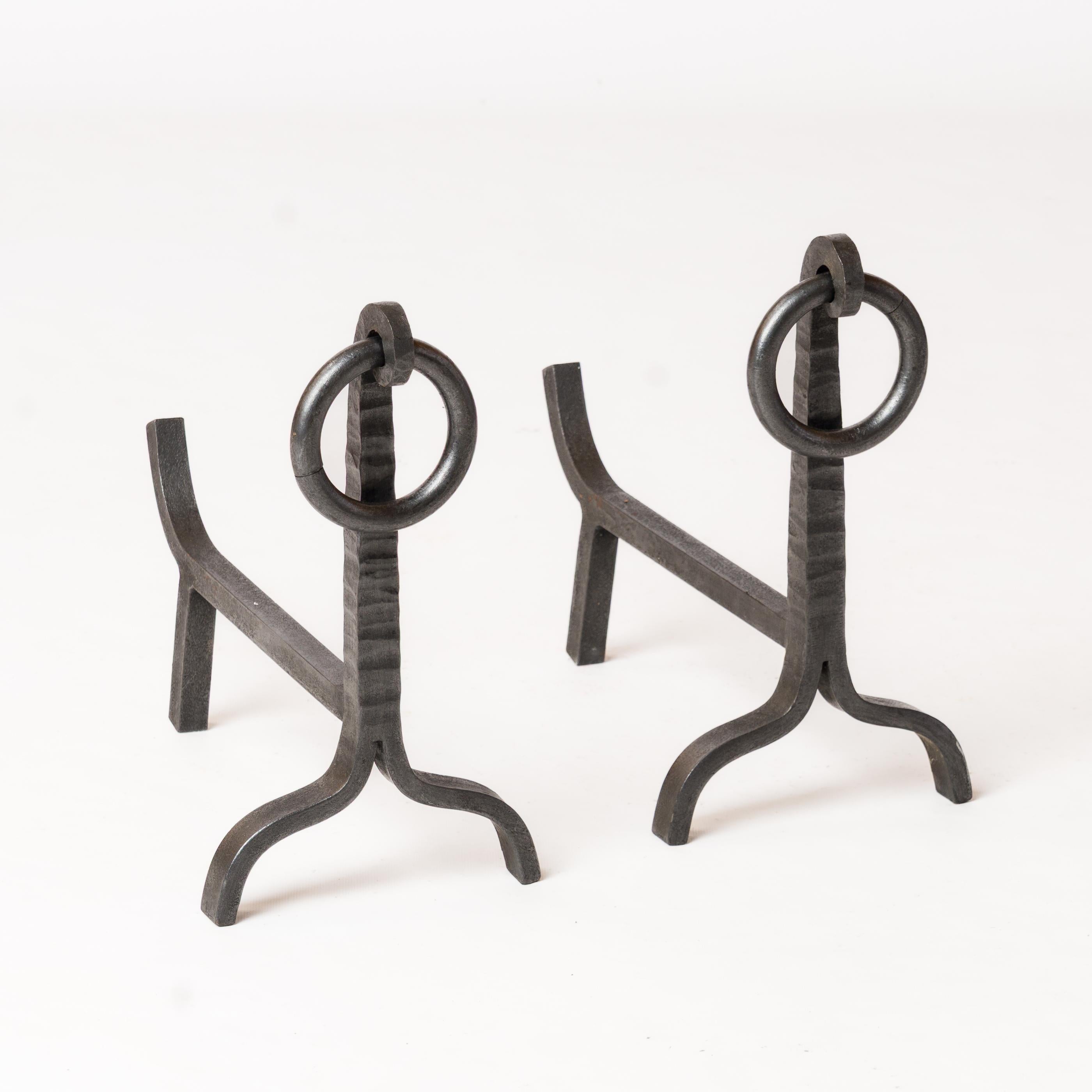 Pair of elegant wrought iron andirons with handling hoops. In fair vintage condition. These andirons will ship from France and can be returned to either France or to an upstate NY facility. Price includes shipping to the US except for possible