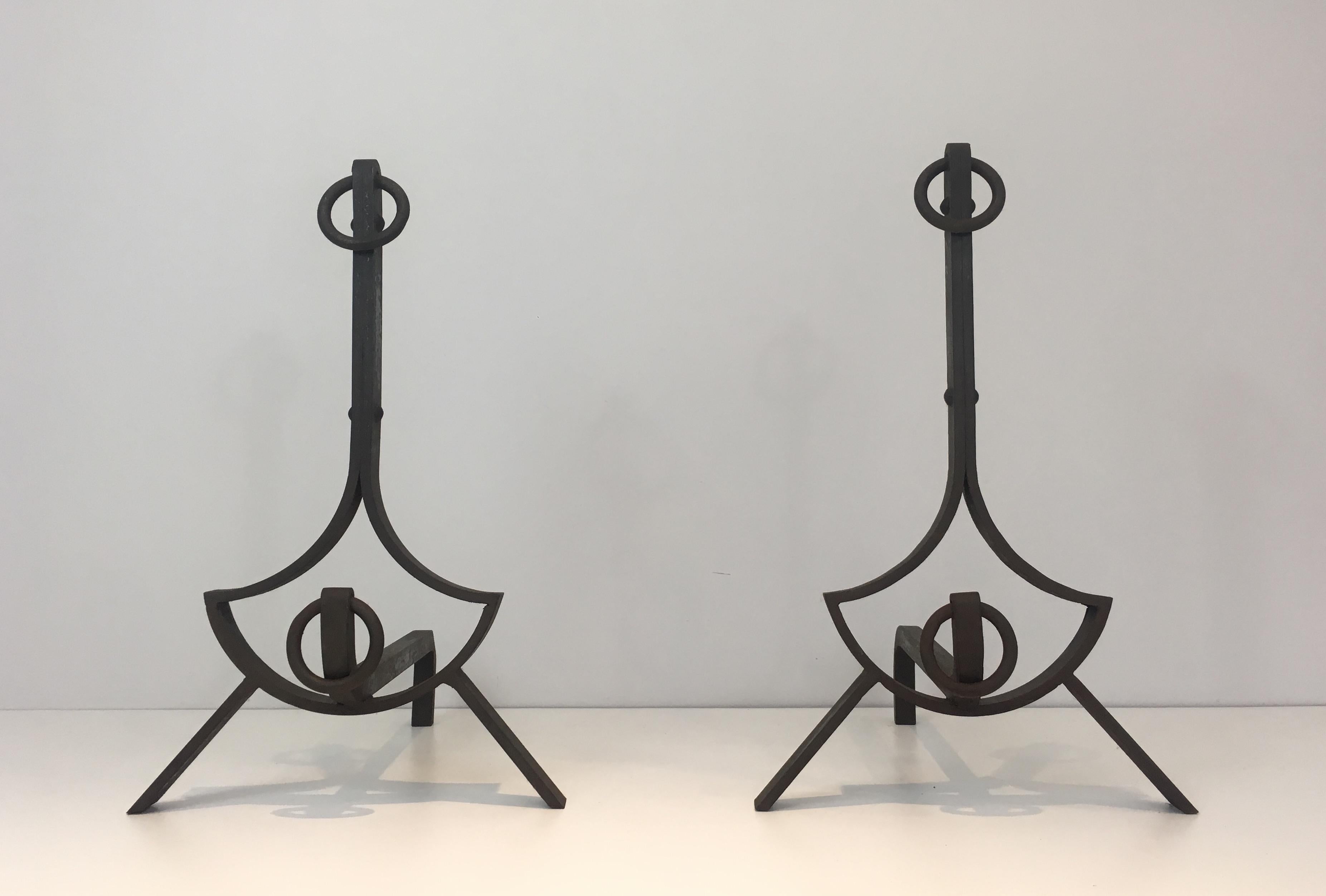 This pair of modernist wrought iron andirons have pure lines and are very elegant. Very nice quality with rivets. French work, circa 1940.