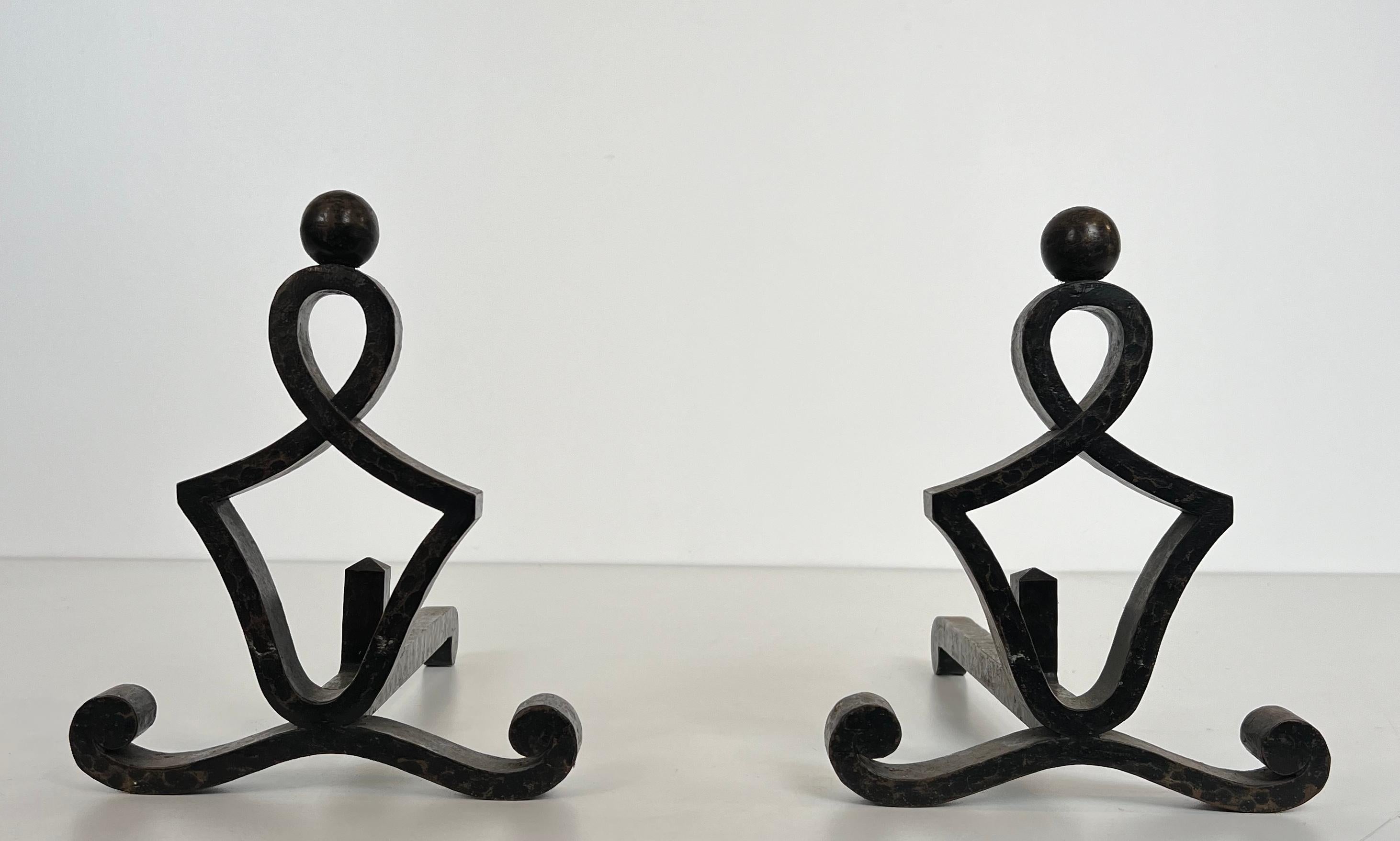 This pair of modernist andirons is made of wrought iron. This is a French work. Circa 1940.