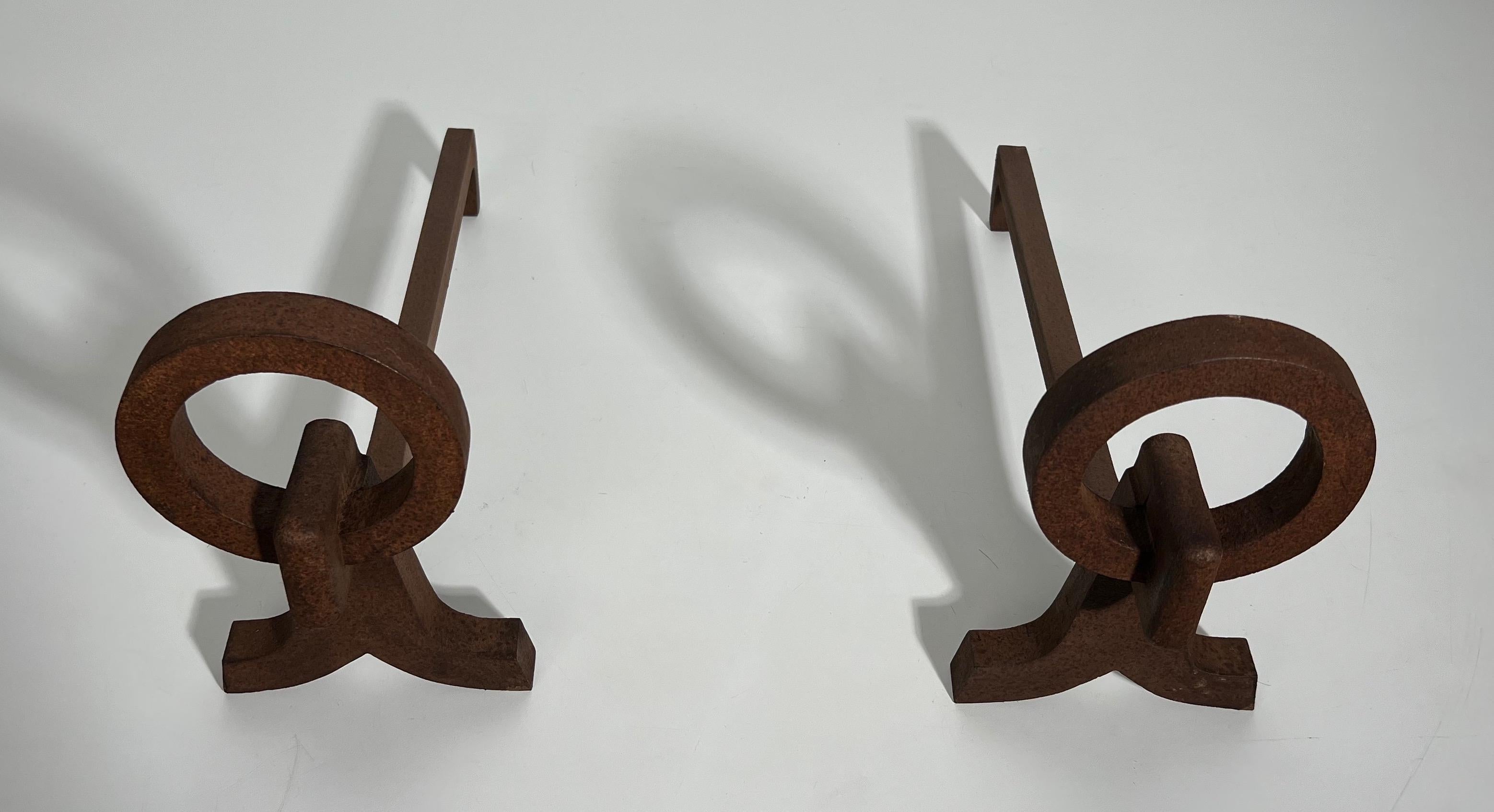 This pair of modernist andirons is made of wrought iron. This is a French work in the style of Jacques Adnet. Circa 1950