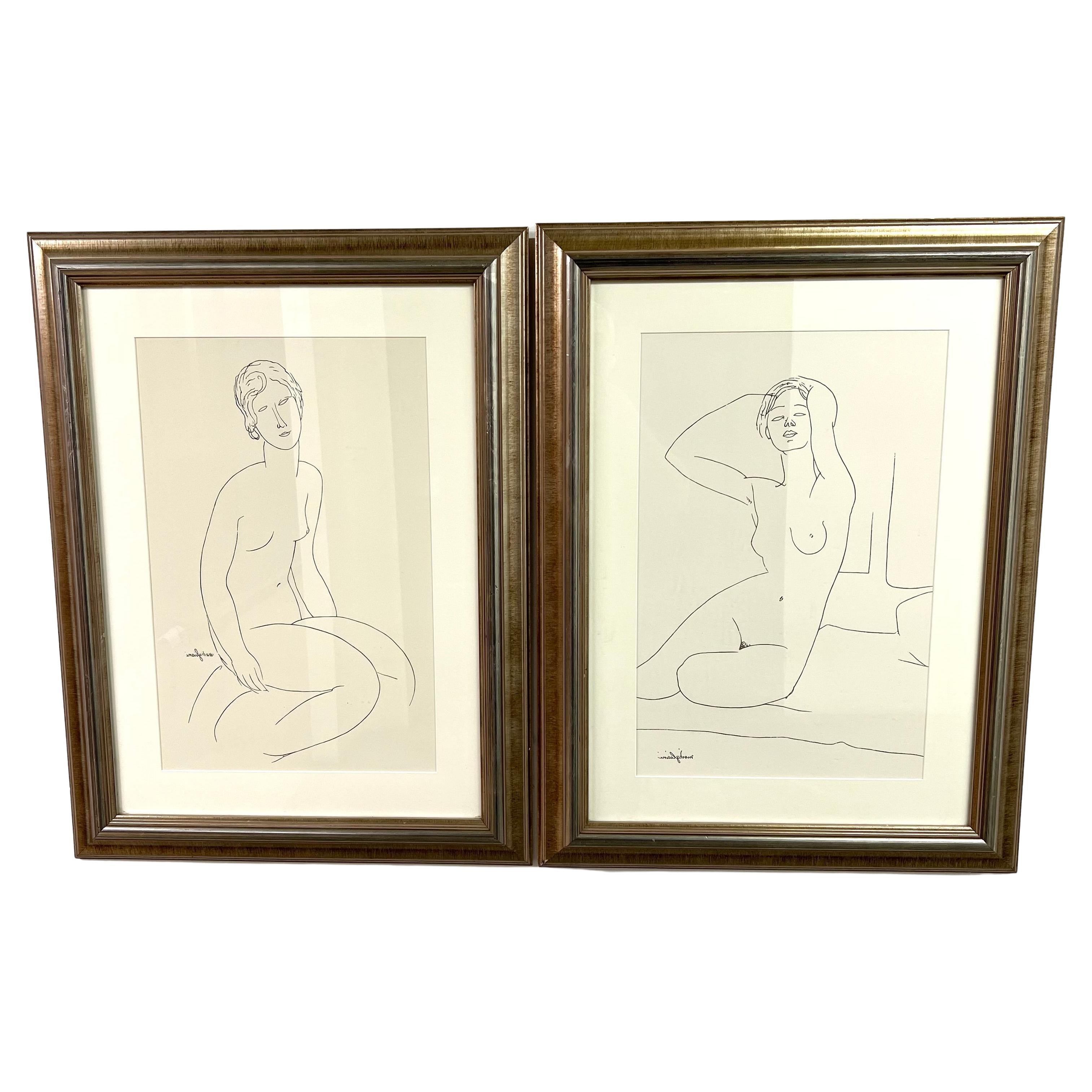 Pair of framed prints in the style of Italian artist Amedeo Modigliani. Gestural line drawings of two female figures are set in matching gold-colored frames and look great side-by-side. A wonderful accent to any wall. 
The pieces are lovely