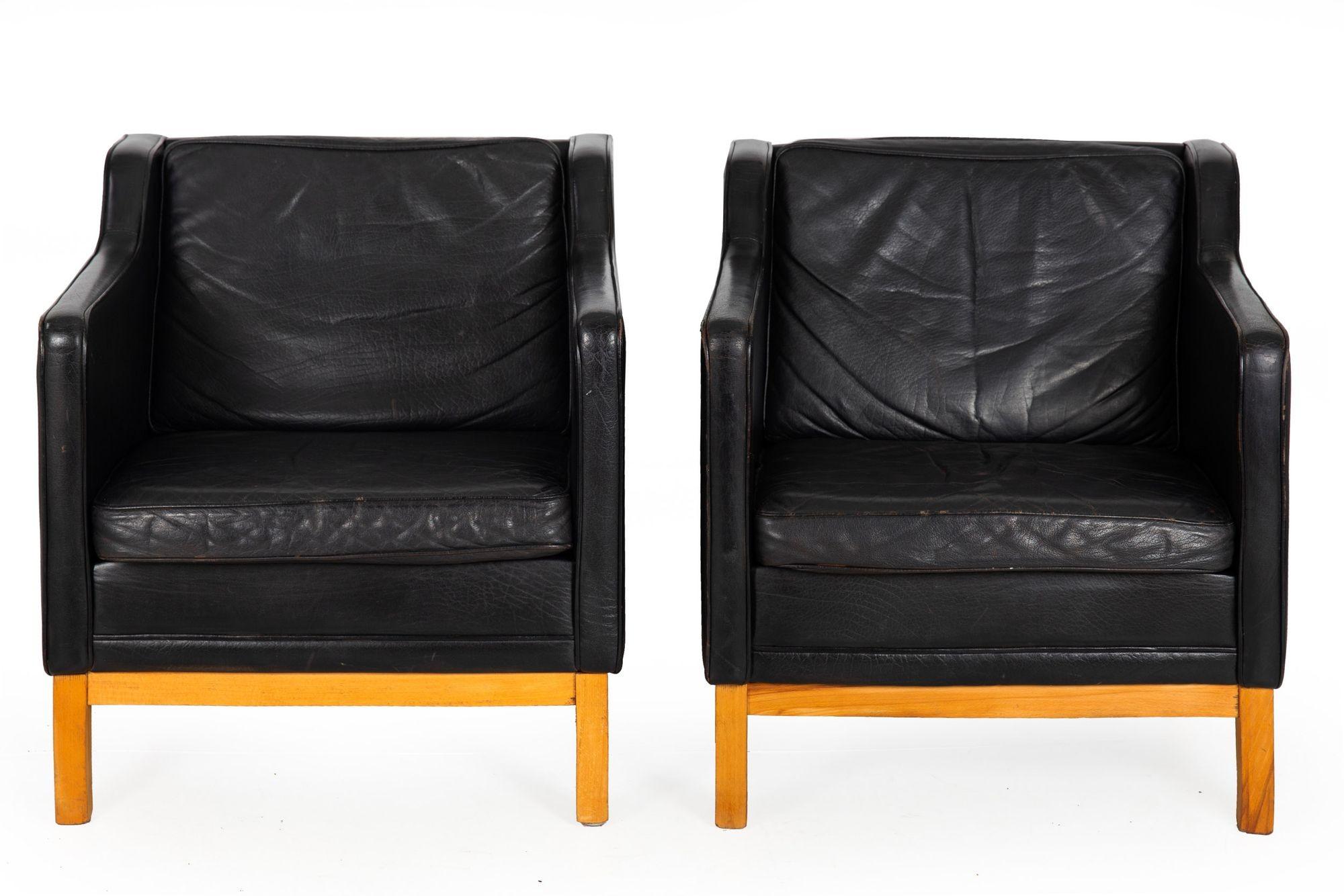 PAIR OF MH195 LOWBACK ARMCHAIRS WITH OTTOMAN BY MOGENS HANSEN
In top-grain black leather with blonde beechwood frames  last quarter of the 20th century
Item # 306LIK27P

This very nicely patinated pair of MH195 lowback armchairs retain their