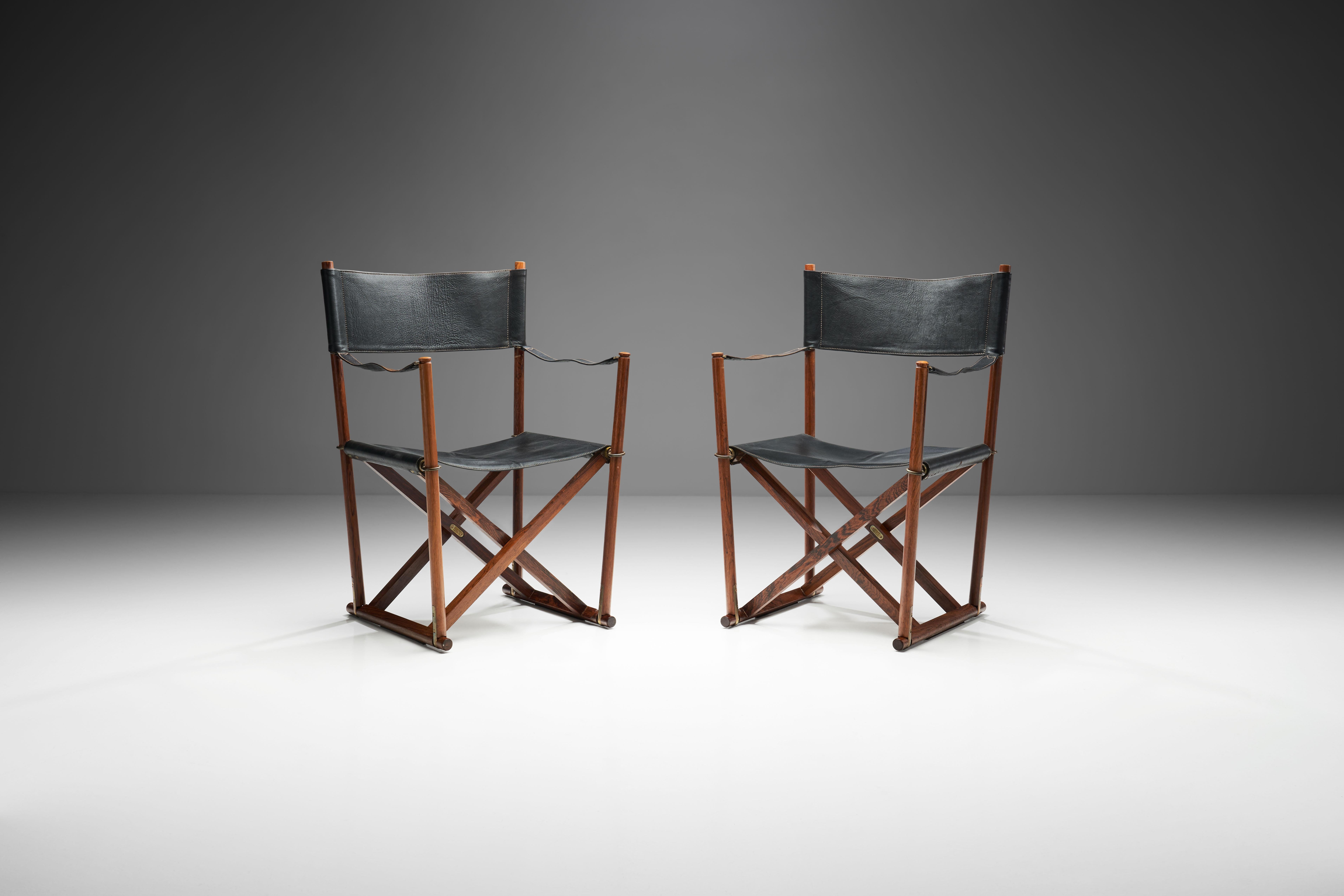 This pair of Mogens Koch’s “MK 16” armchairs are made of Brazilian wood and feature black leather seats, backs and armrests with a vertically foldable frame. The chairs have brass plaques with Mogens Koch’s and the manufacturer’s name as well as the