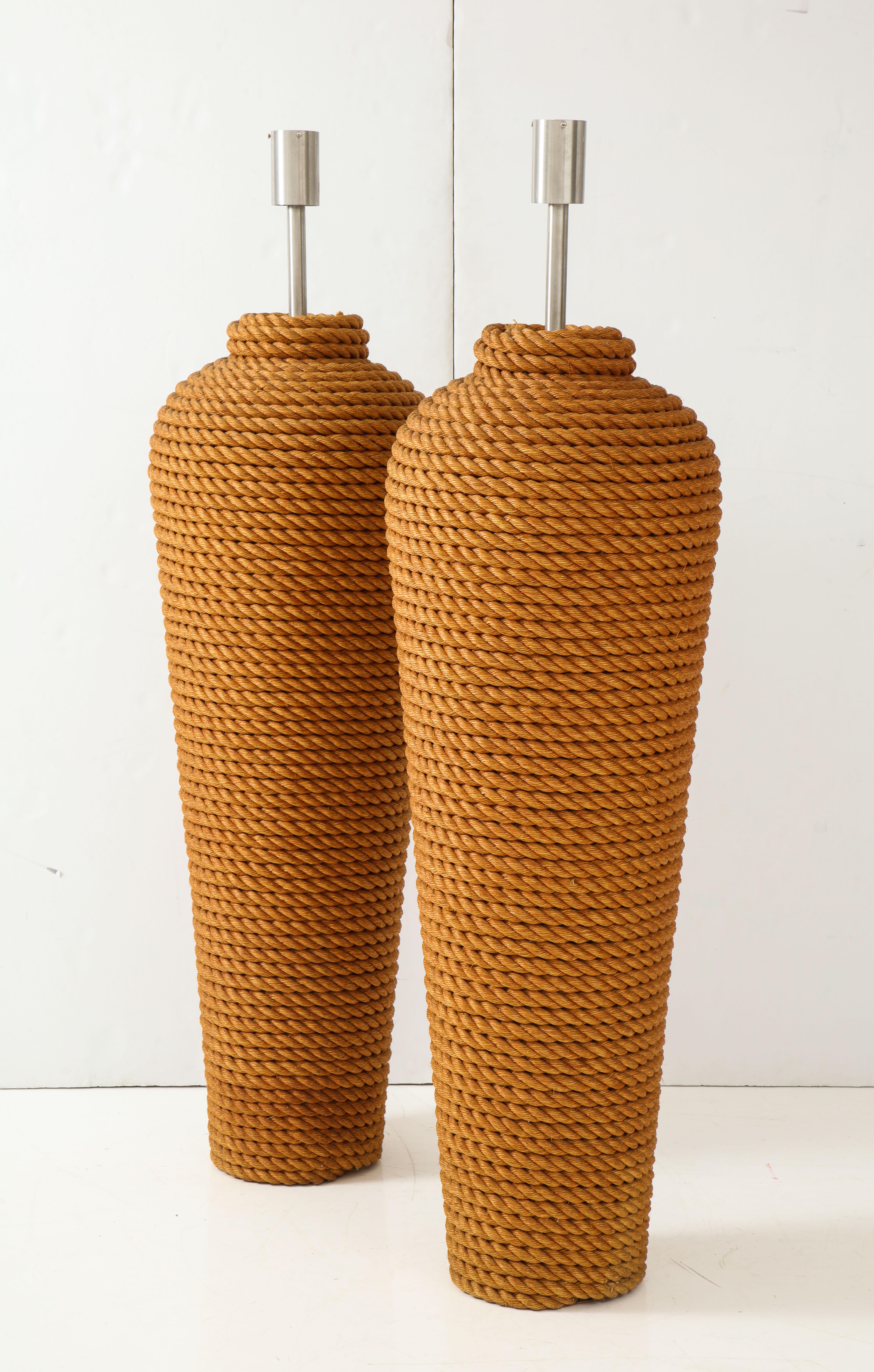 Pair of monumental 1960s French rope floor lamps.
The lamps are completely covered in heavy coiled bands of rope.
They have been newly rewired for the US with a floor dimmer switch.
These lamps are a statement piece.