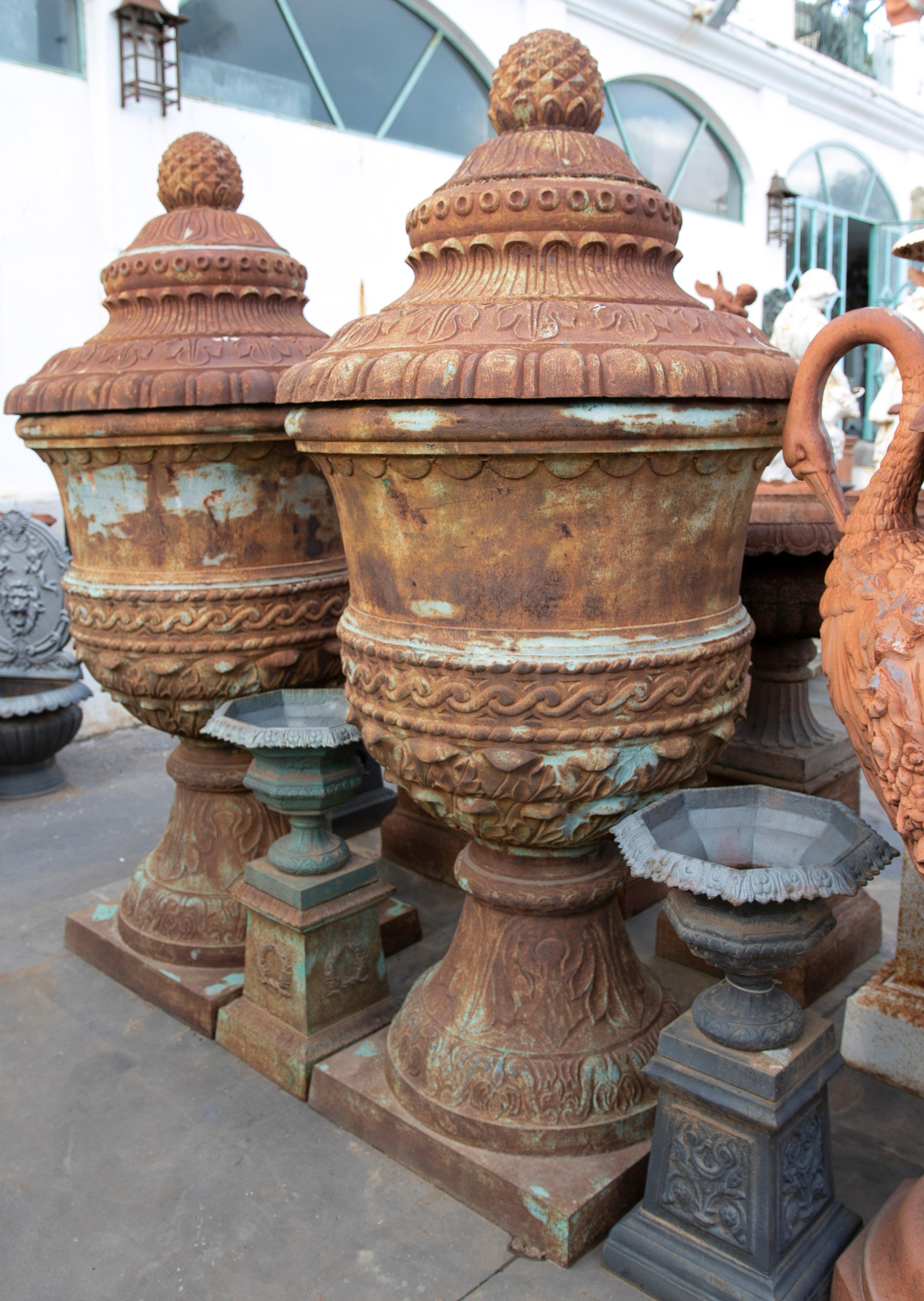 Pair of monumental 1990s classical cast iron garden urn planters with lids. We have preferred to let the paint weather to increase the character of the pieces. 

Matching pair of bases available.