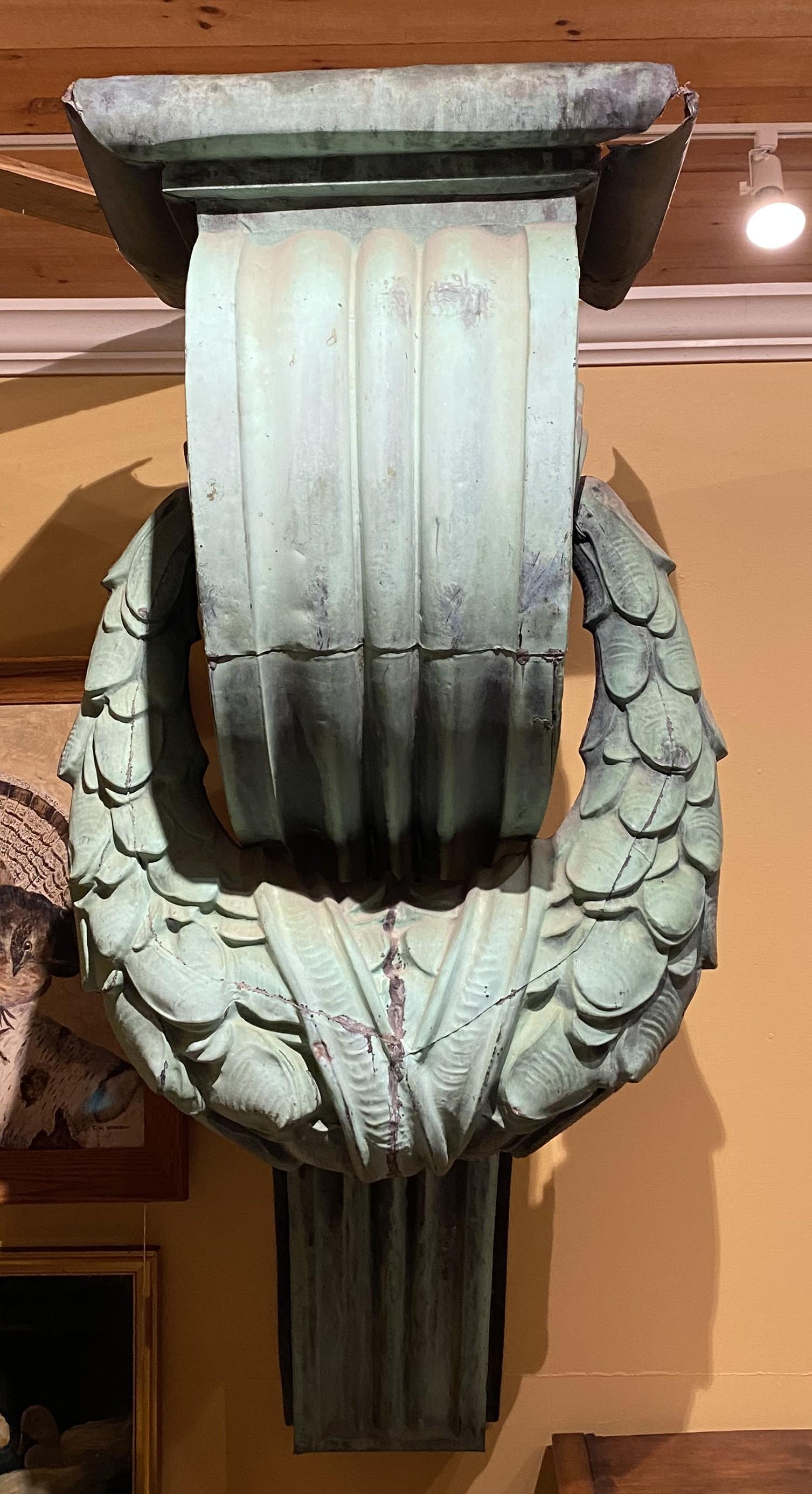 A monumental pair of copper corbels in scroll form with foliate swags with a great verdigris surface, probably New York origin, dating to the late 19th century. Includes custom L form iron wall brackets for easy installation. Very good overall