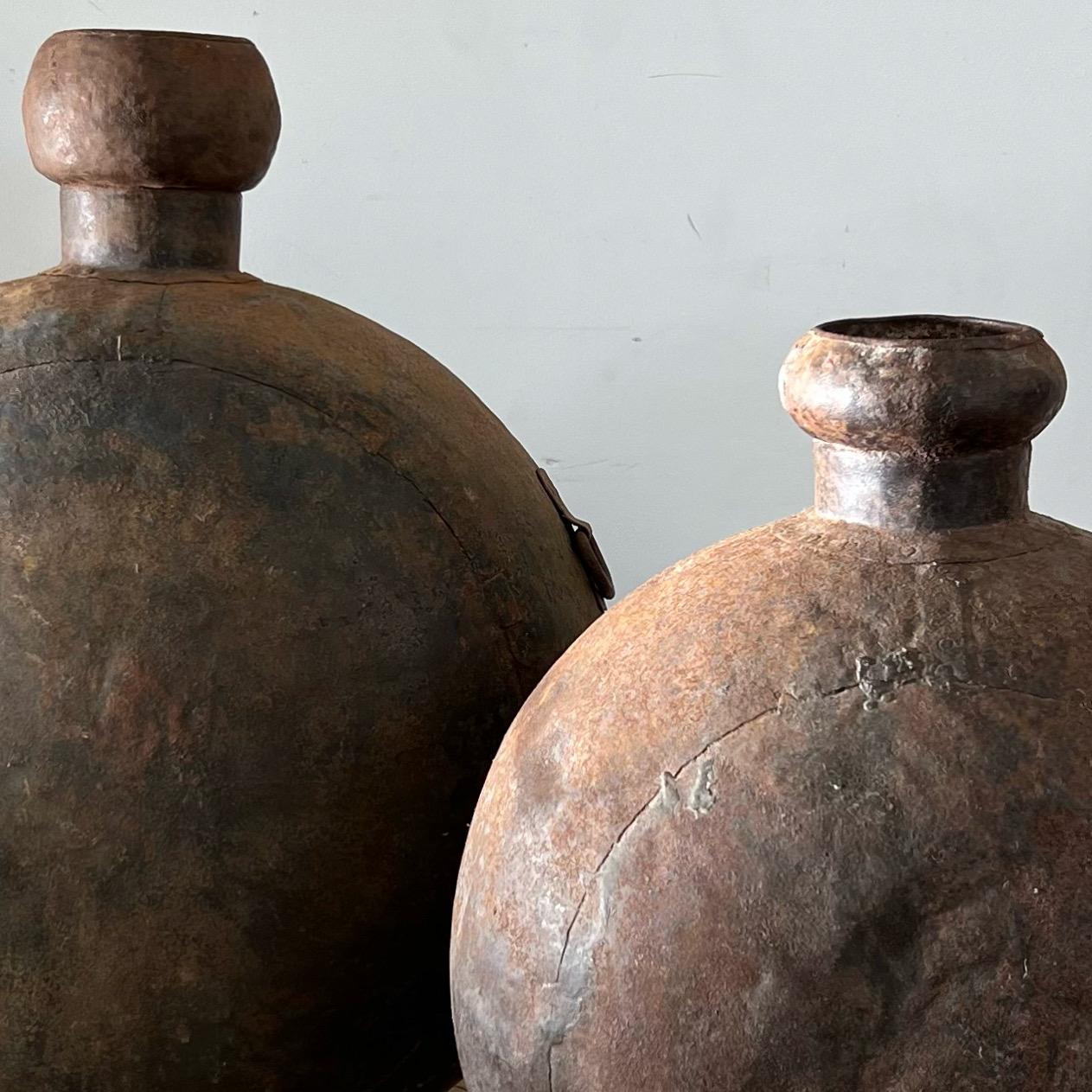 A pair of huge weathered cast iron vessels. The glorious epitome of patination. The larger with handles and the smaller sans. Fabulous as interior home decor or outdoor garden ornamentation. Pick up in LA or worldwide delivery options available.