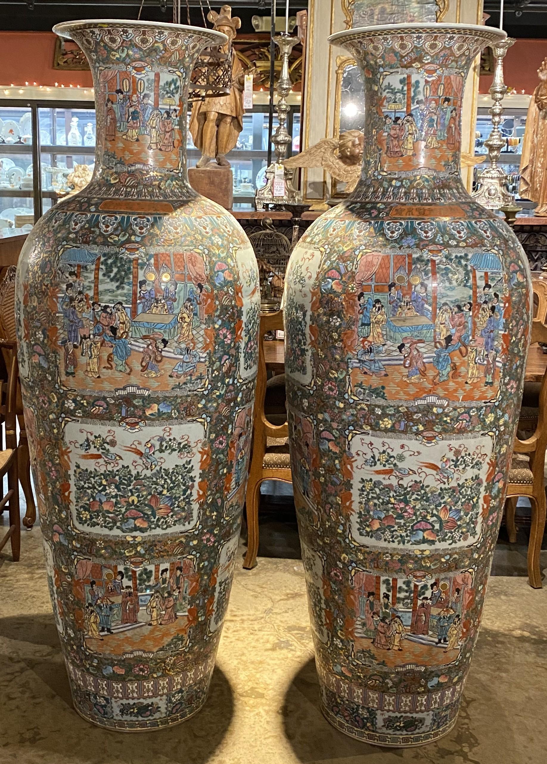 An exceptional pair of polychrome Chinese Rose Medallion palace vases of monumental size with flared decorated lips, several different cartouche scenes of birds, flowers, and interior scenes with figures, surrounded by geometric, floral and