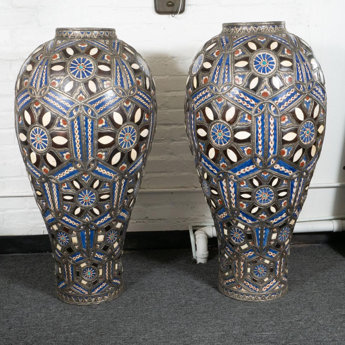 Pair of colorful, blue, white and red, large-scale ceramic Moroccan vases. The vases feature beautifully inlayed and painted elements to create a stunning mosaic effect and an intricately pressed metal trim as framing. Incredible details all around.