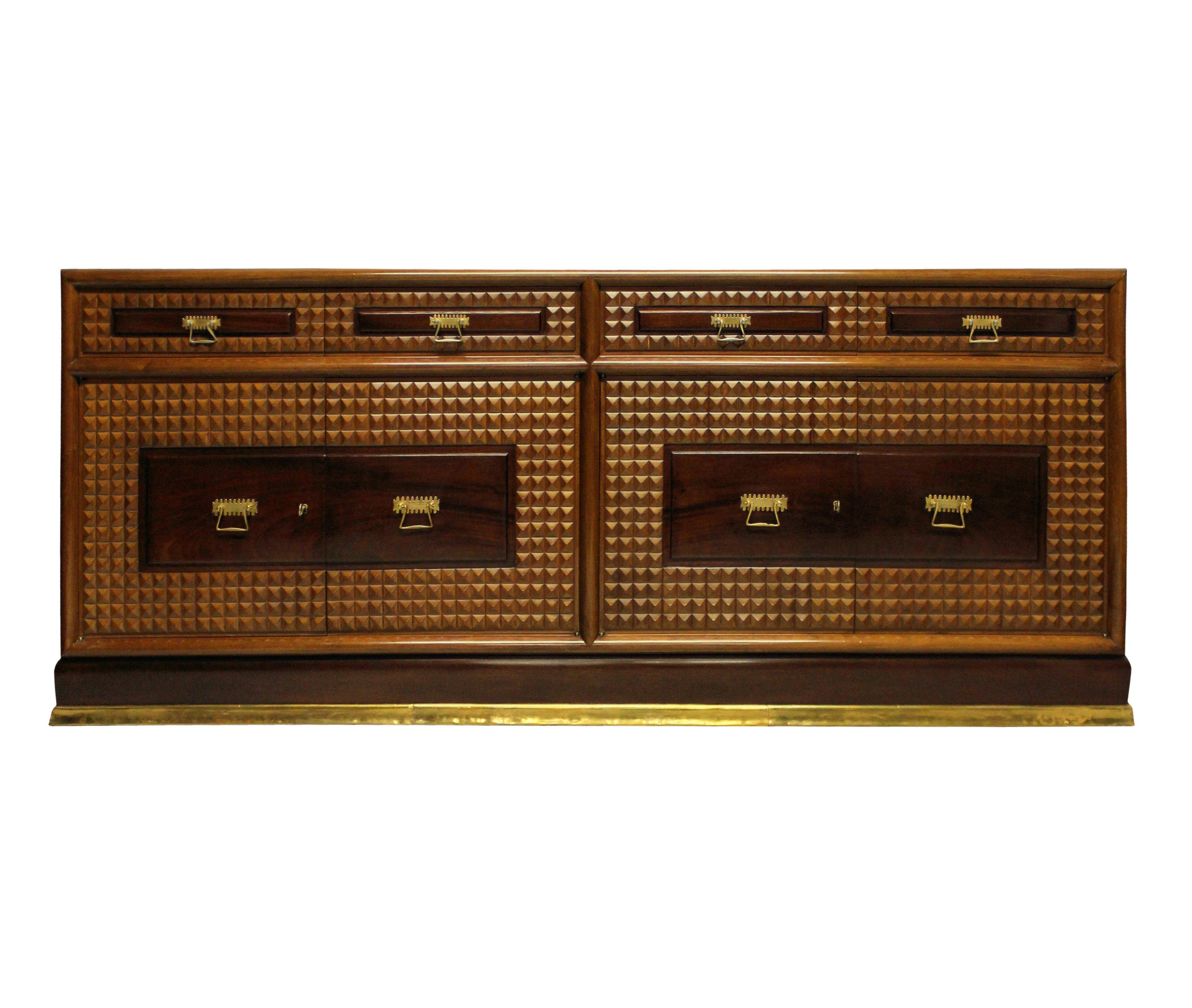 A pair of monumental Italian credenzas of superb quality by Atelier Borsani. Each with central cupboards lined in blond wood and four drawers. The exterior is comprised of various walnut veneers, with a finely carved geometric diamond pattern