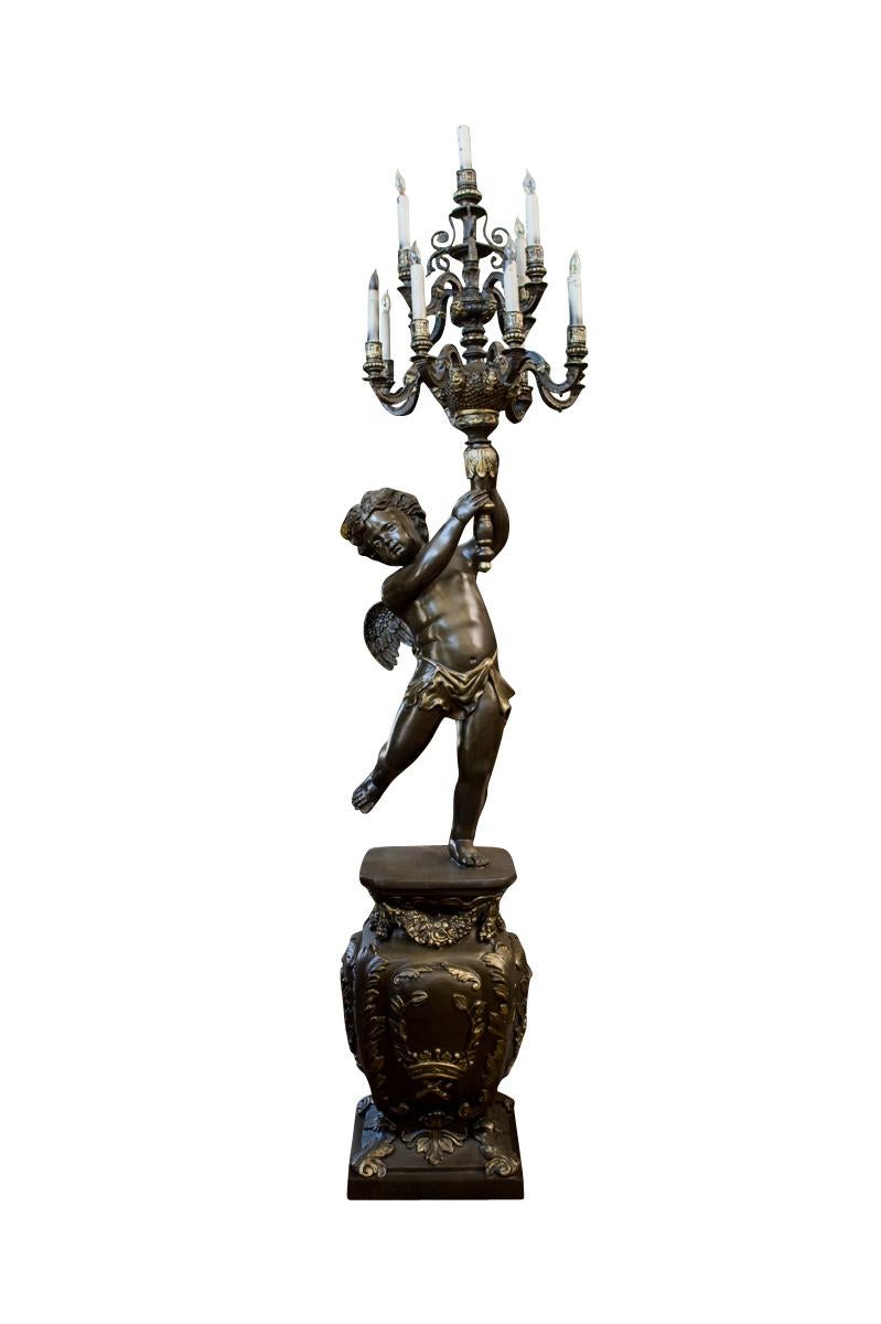 A pair of large French Napoleon III style metal thirteen-light figural torchières.depicting two winged cherubs holding up a thirteen-light torchère, standing on bases with gold highlights.

20th century

Dimensions
Height: 91”  (231 cm)
Width: 25” 