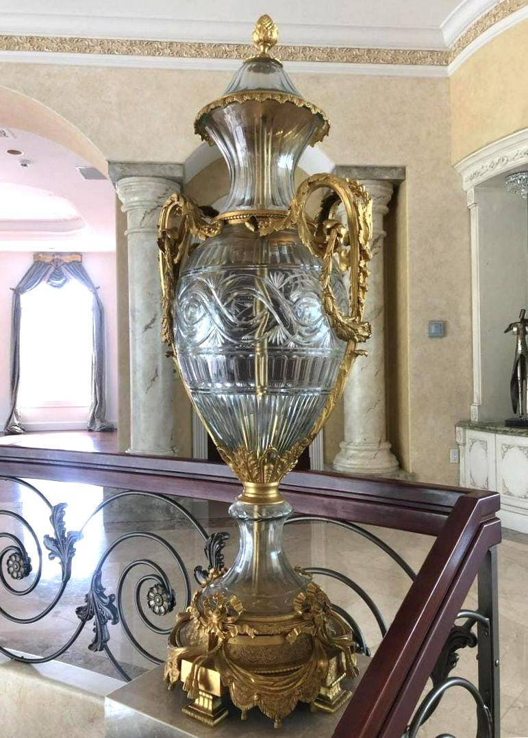 Pair of monumental Louis XVI style gilt bronze mounted crystal covered urns on later adapted marble base.
Urns 19 x 18 x 72 inches including pedestals. Just the covered urns 55.5 x 19 x 18 inches alone.
 