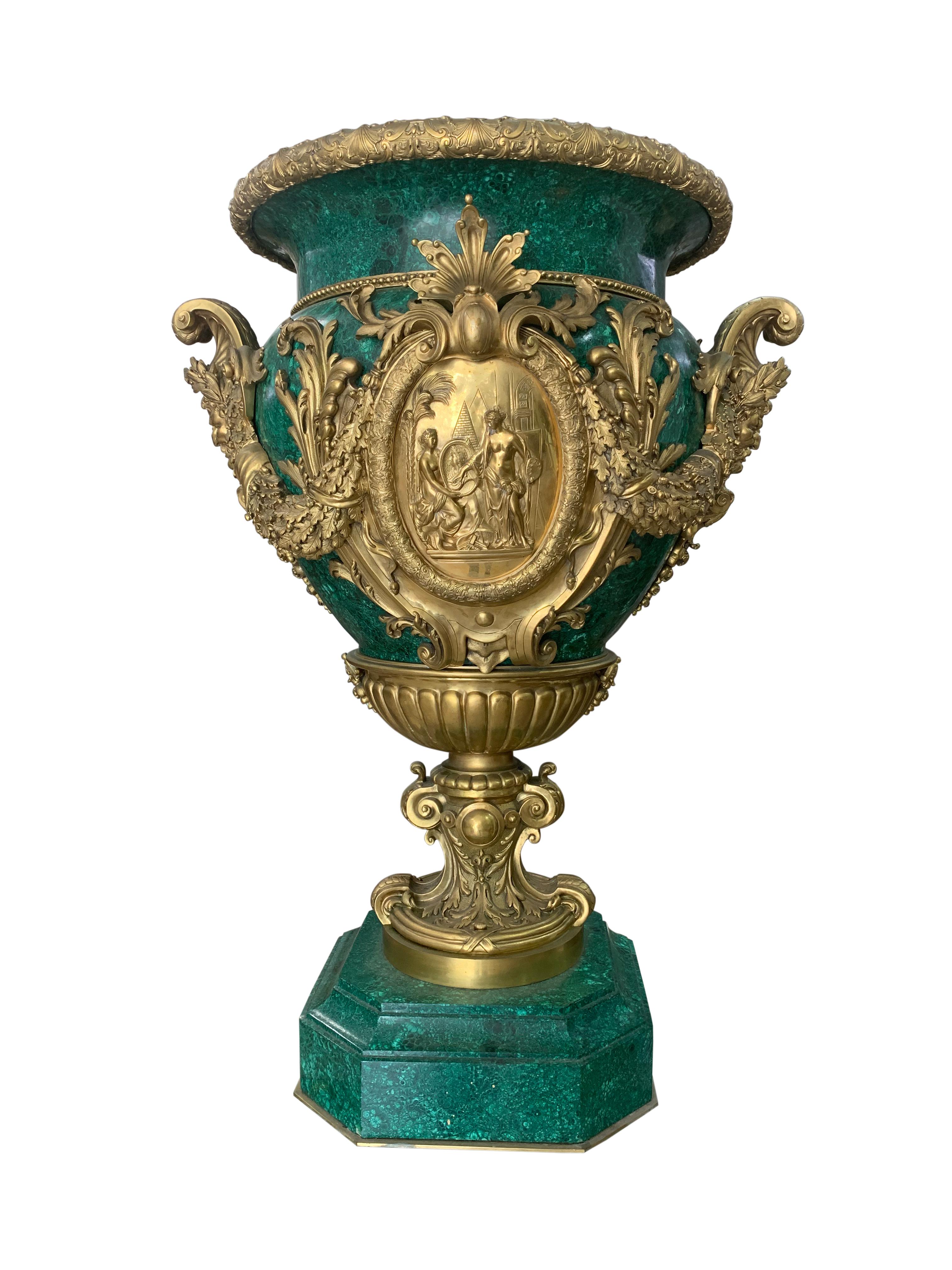 An very high quality pair of Belle Époque style gilt bronze and malachite urns. . Each with Berainesque gilt bronze tracery cast everted rim above a vessel mounted with oval plaques within acorn and oak leaf frames, the first depicting two partially