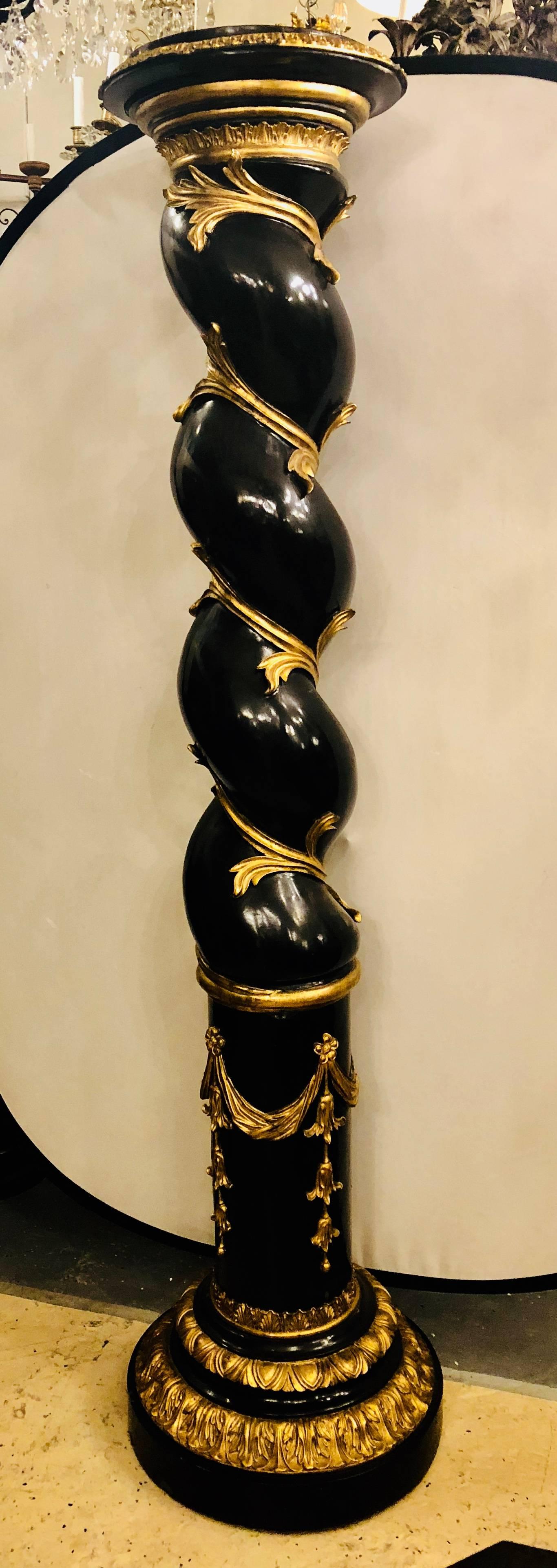 Pair of monumental Hollywood Regency style pedestals ebony and gilt gold detail. Each barley twisted enormous pedestal has fine gilt gold vines running up and down the frame. A large pair of show stoppers for those looking to really open the eyes of