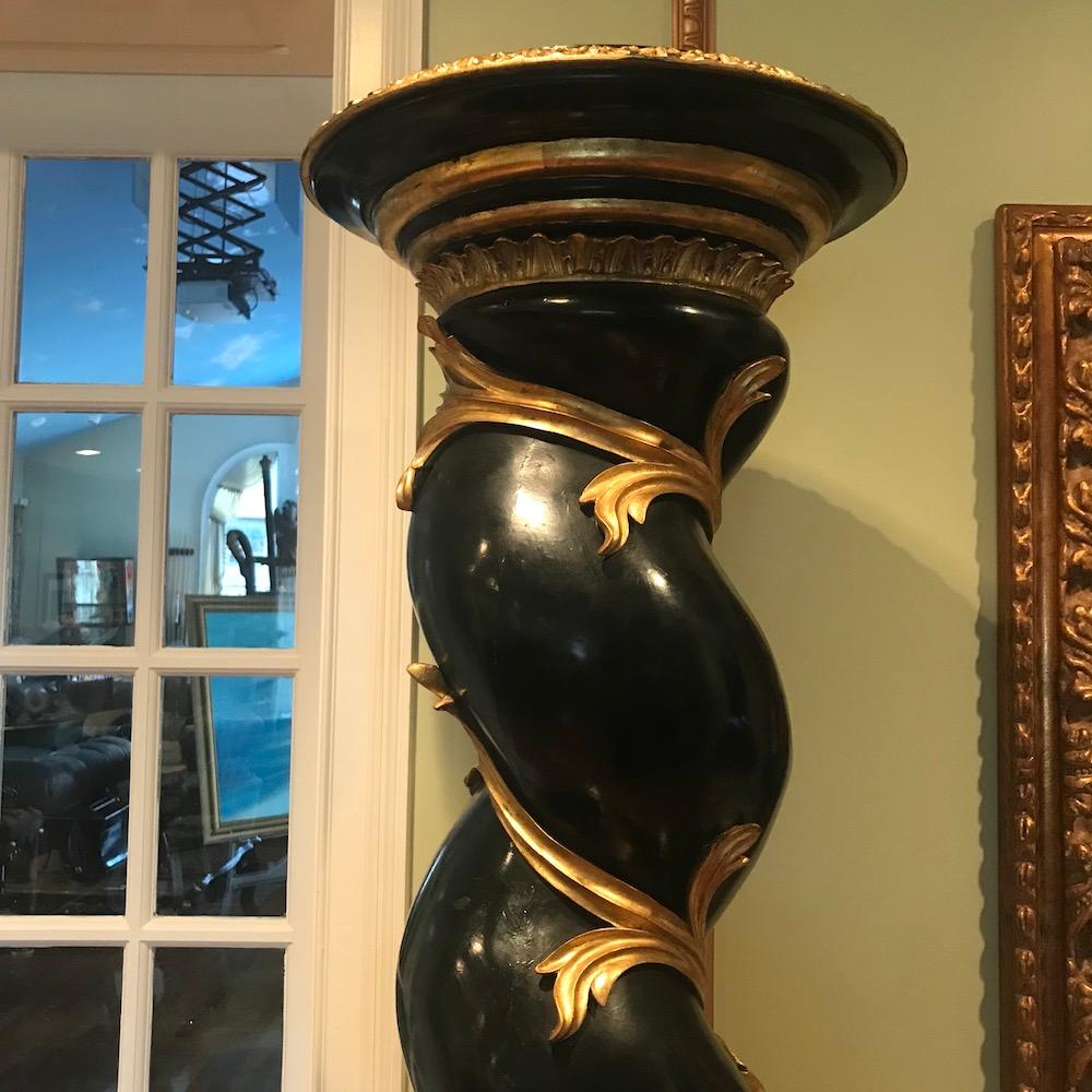 Pair of tall ebonized and parcel-gilt columns with twisted form at top over block case with gilt adornments. Approximate 81.25