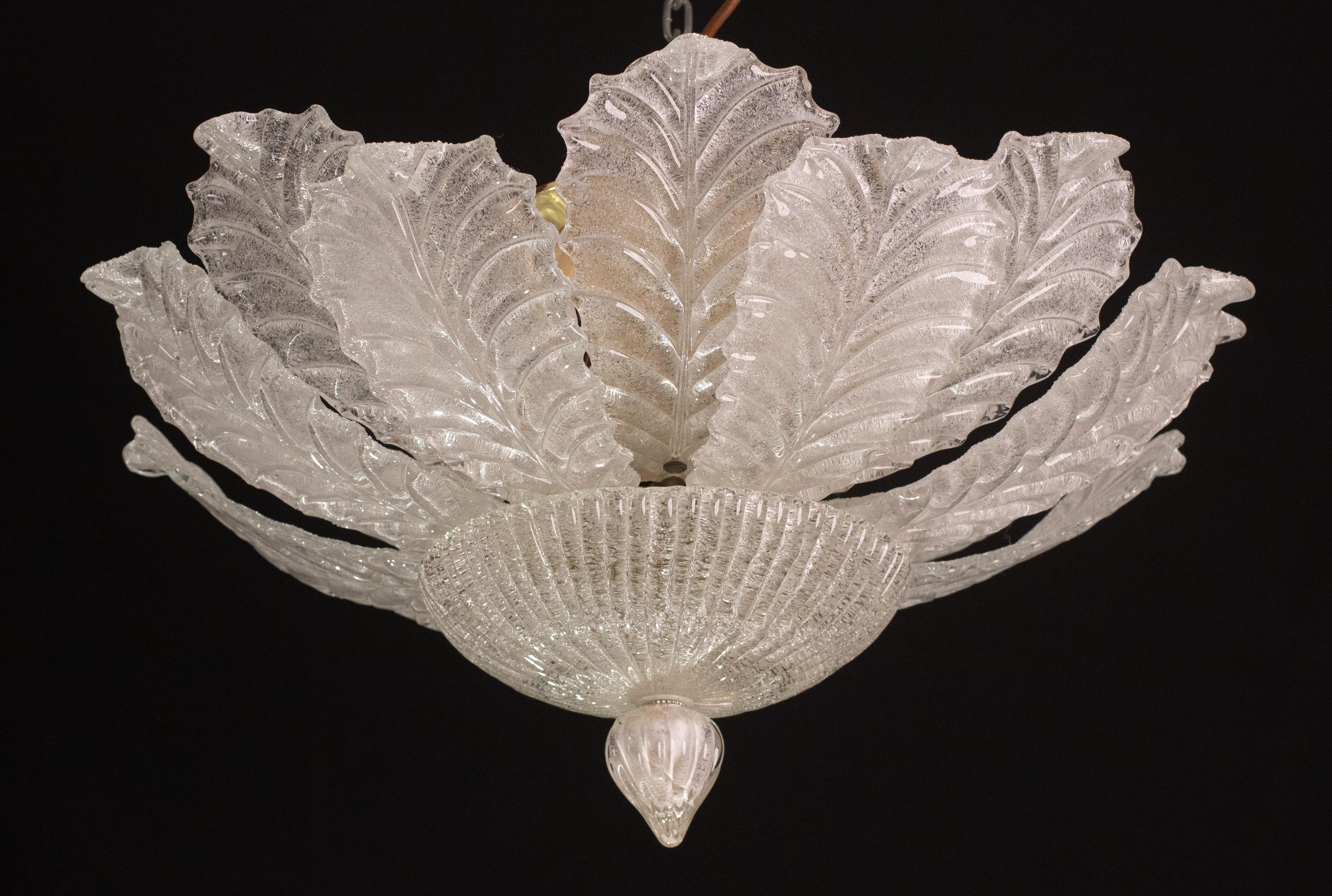 Splendid pair of Murano glass ceiling lamps.

Period: circa 1970.

Each ceiling light mounts 6 European standard e14 lamp holders, possibility of wiring for Usa.

Each ceiling light consists of 16 glass leaves plus 2 central glass elements.

The