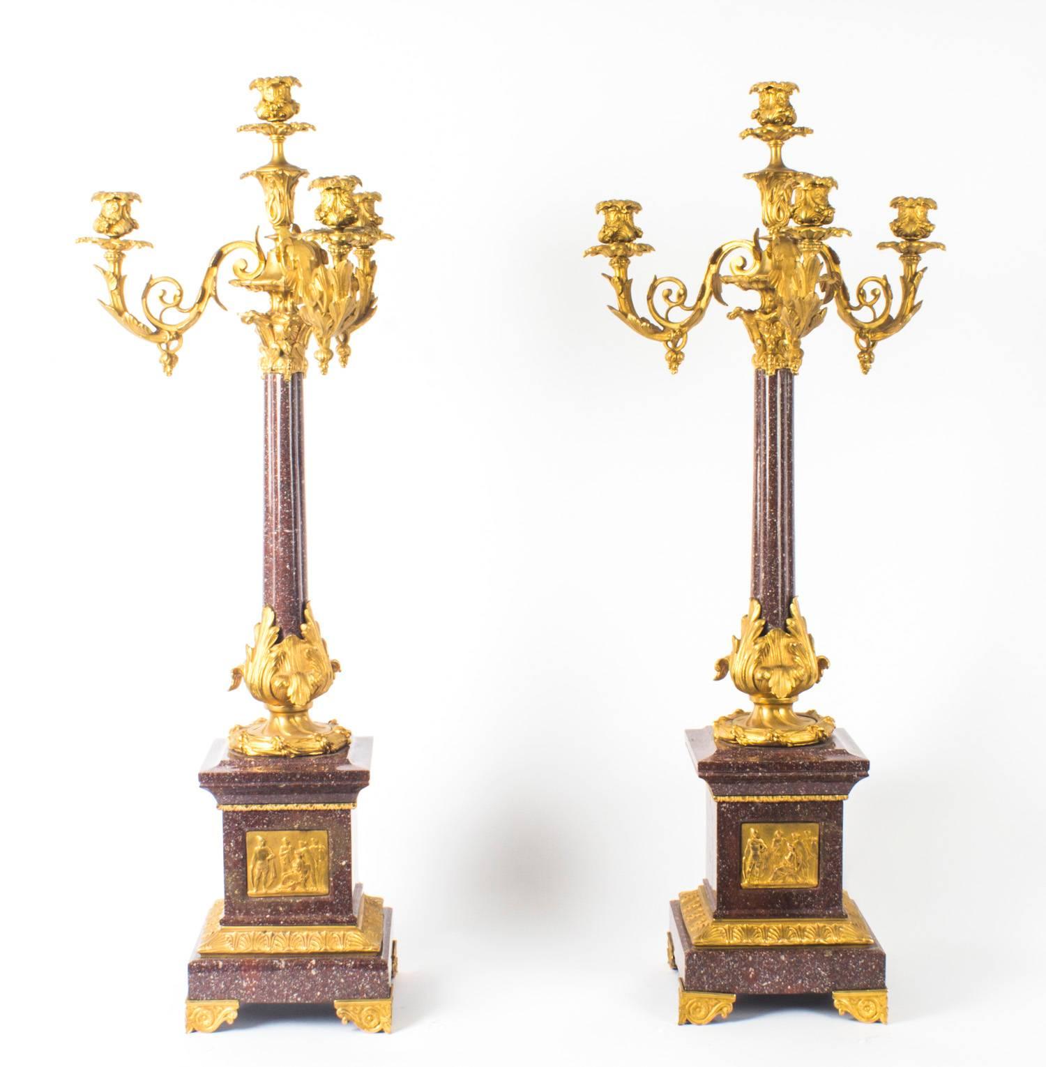 This is a large impressive antique pair of Louis Revival ormolu and porphyry four light, candelabra, circa 1860 in date.
 
This lovely pair of candelabra rise from stepped square bases each bearing an ormolu plaque of a classical Roman scene in