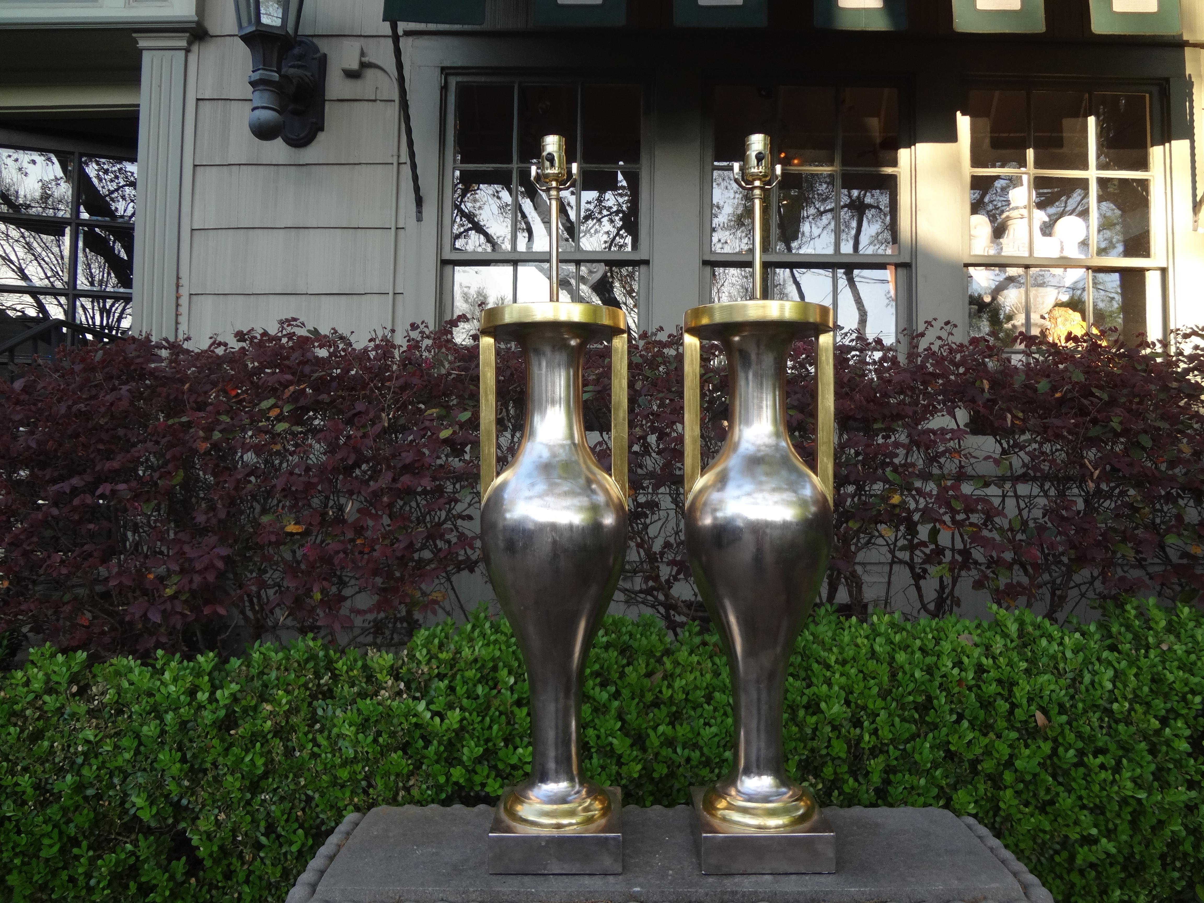 Pair of monumental Neoclassical style silver and gold giltwood urn form lamps.
Sensational pair of Neoclassical style silver gilt wood urn form lamps with gold giltwood handles. This monumental pair of silver leaf and gold leaf urn lamps attributed