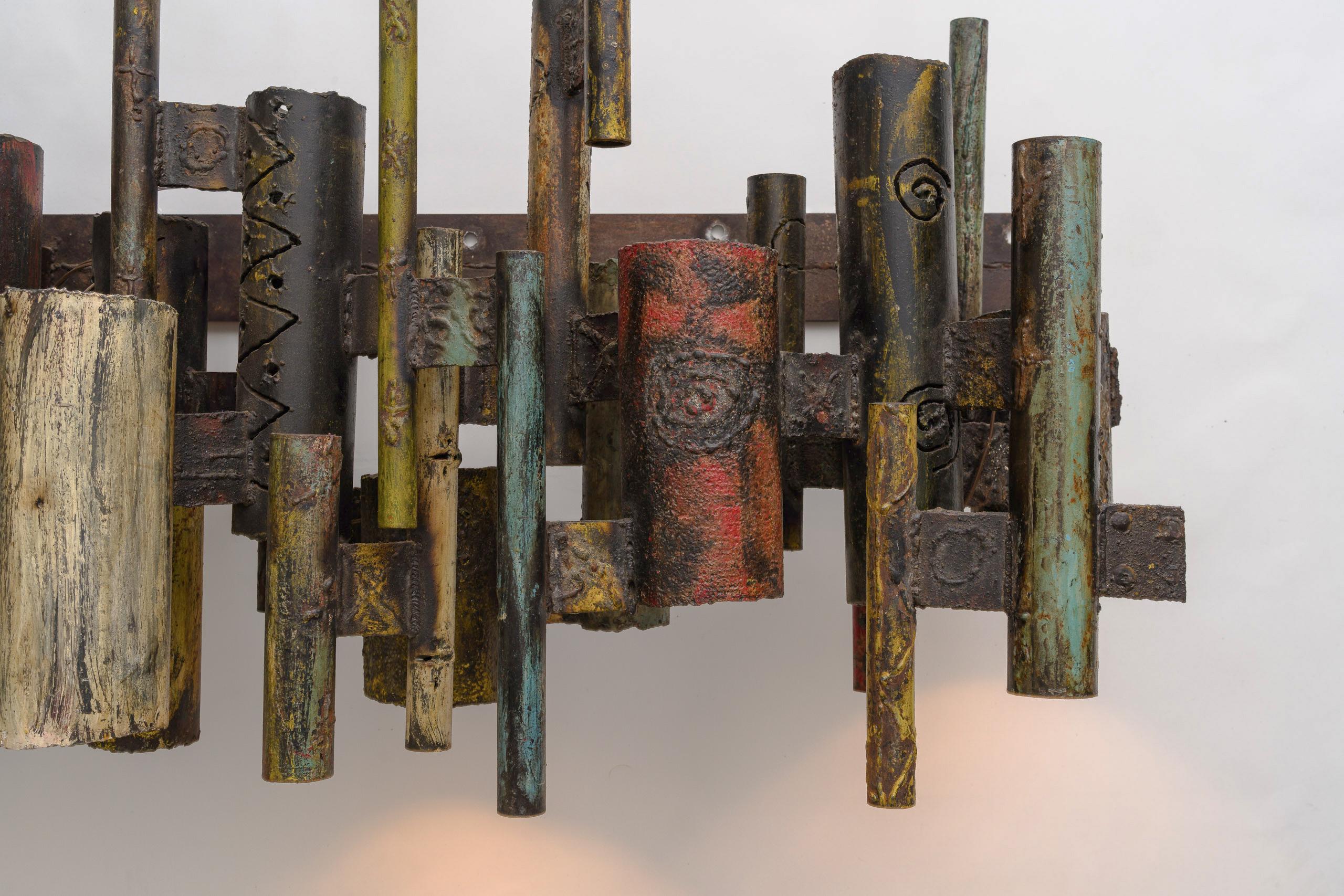 In a breathtaking display of avant-garde design, this unique pair of Paul Evans Studio Monumental Sconces, boast an unexpected scale, each measuring an impressive 48 inches wide—a departure from Evans’ typically modest lighting creations. Each