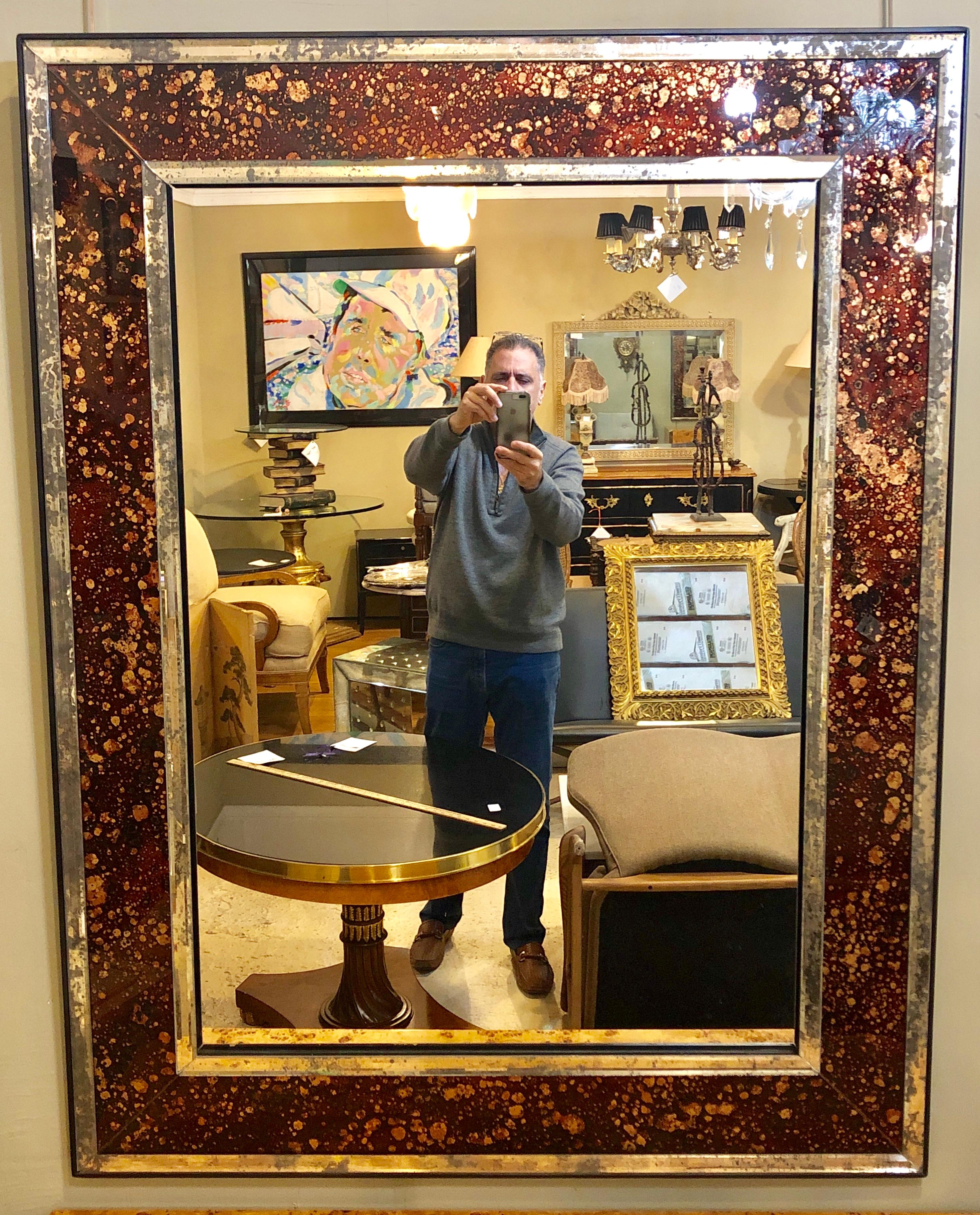 Finest Hollywood Regency pair of monumental tortoise shell beveled bordered console or wall mirrors. These spectacular wall or console mirrors have a clear center mirror with an antiqued beveled mirror frame flanking a finely etched tortoise shell