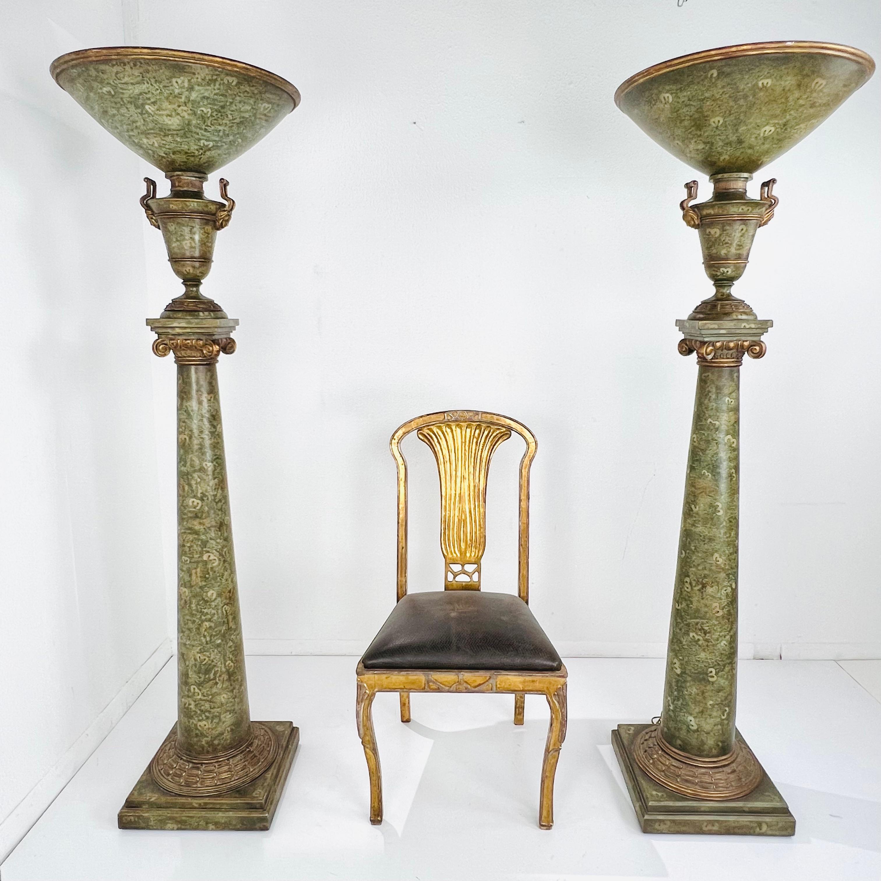 Unique pair of massive scale painted wood and metal floor lamps. Rich shades of green with gilded accents and ornate carved face and scroll detail. Good vintage condition, lights are tested and working.