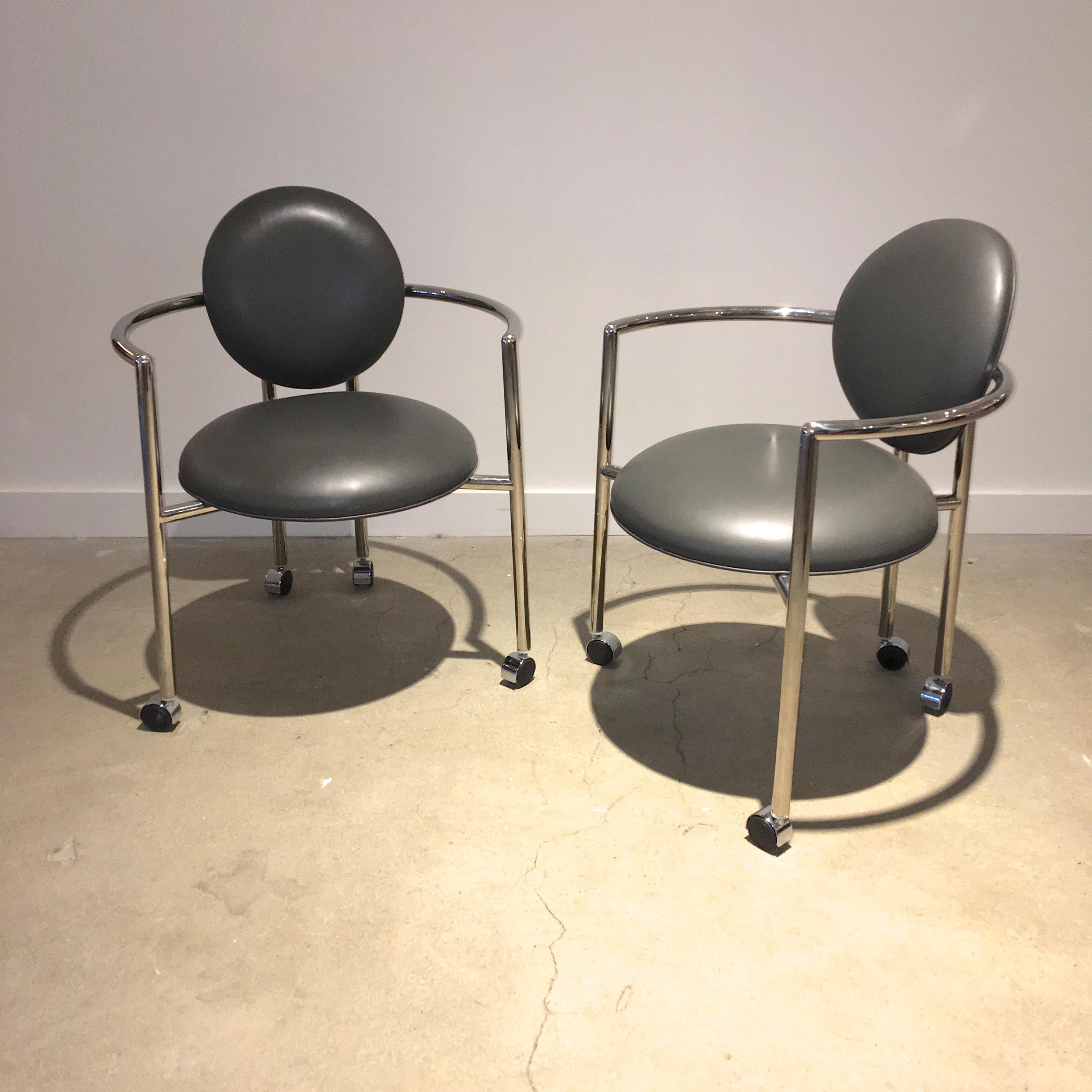 Pair of Moon chairs designed in 1986 by Stanley Jay Friedman for Brueton.
Roundabout frame of mirror polished tubular No. 304 stainless steel arm chairs in the Memphis style. Seat and back upholstered in gray leather. 24