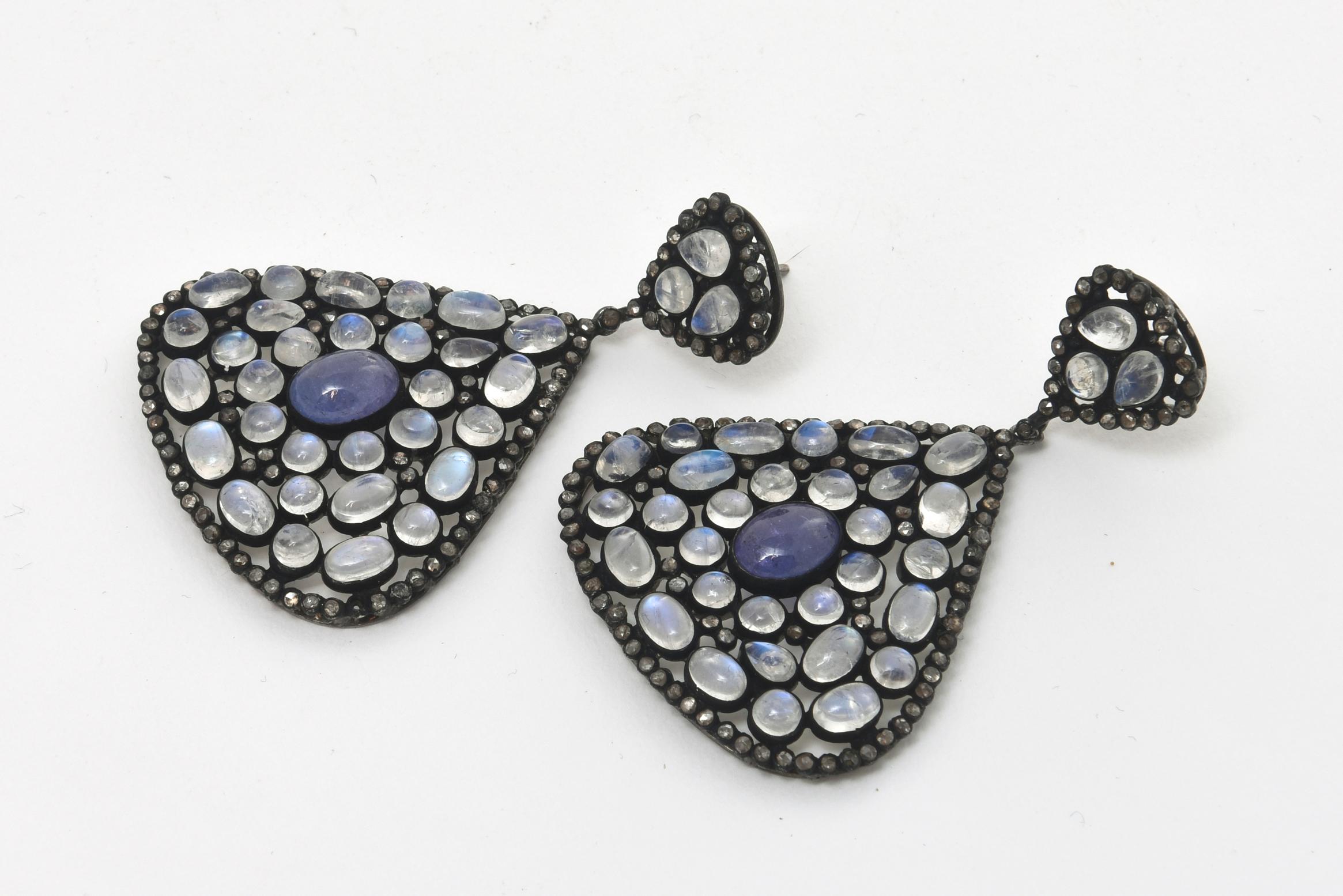 This beautiful pair of Indian inspired with a contemporary twist wide teardrop dangle pierced earrings are the combination of luscious colored stones of tanzanite, moonstone set against black diamonds as the exterior and black rhodium over sterling