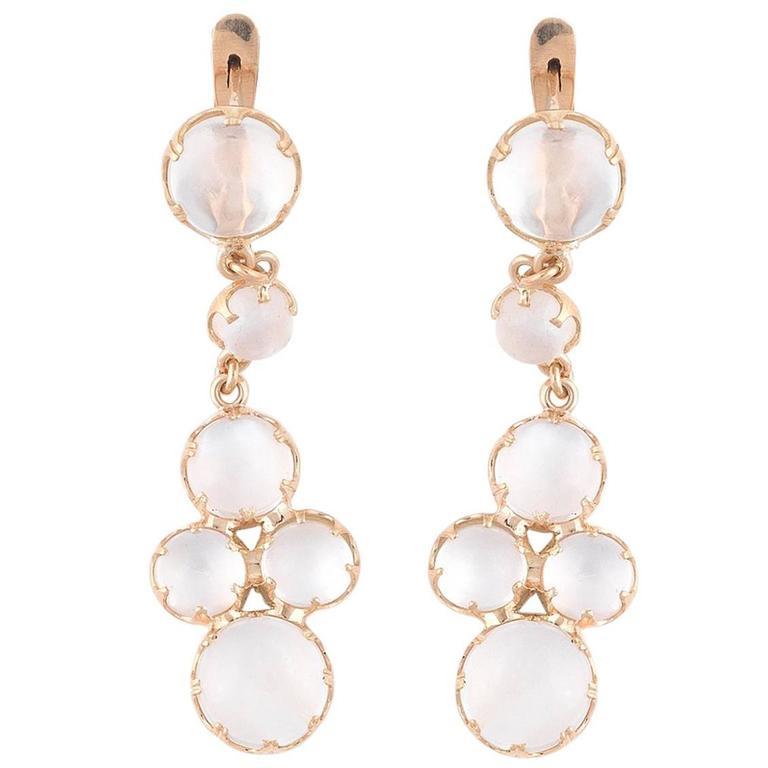 Designed as a coronet set round shape cabochon moonstone suspending another same shape moonstone and an element of four other same shape and set moonstones.

Mounted in 18Kt yellow gold 

4.4 cm long 

Weight: 8 gr