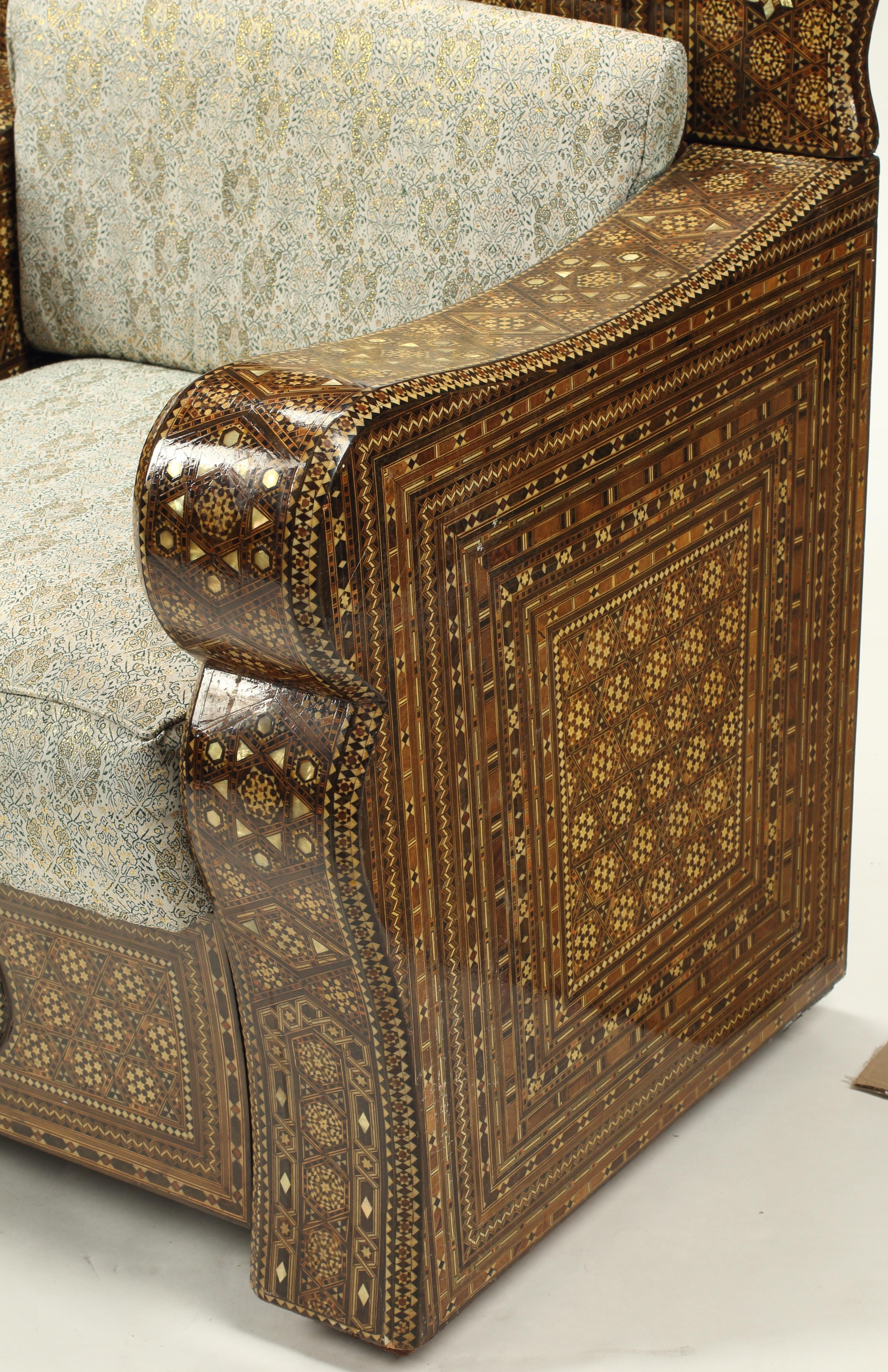 Cette paire de chaises à trône est un exemple étonnant de marqueterie de style mauresque ou levantin utilisant de la nacre. Les motifs géométriques et floraux complexes, typiques de l'art islamique, sont omniprésents. Les hauts dossiers festonnés
