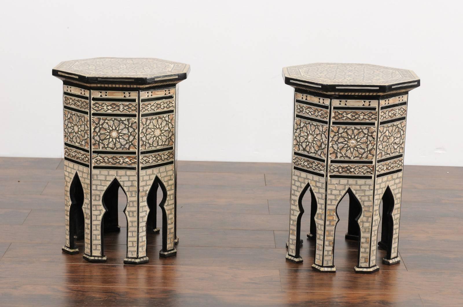 A pair of Syrian Moorish style octagonal side tables with ebonized wood and mother-of-pearl inlay from the early 20th century. Each of this pair of Syrian tables features an exquisite décor, where no area is left untouched, evoking something that is