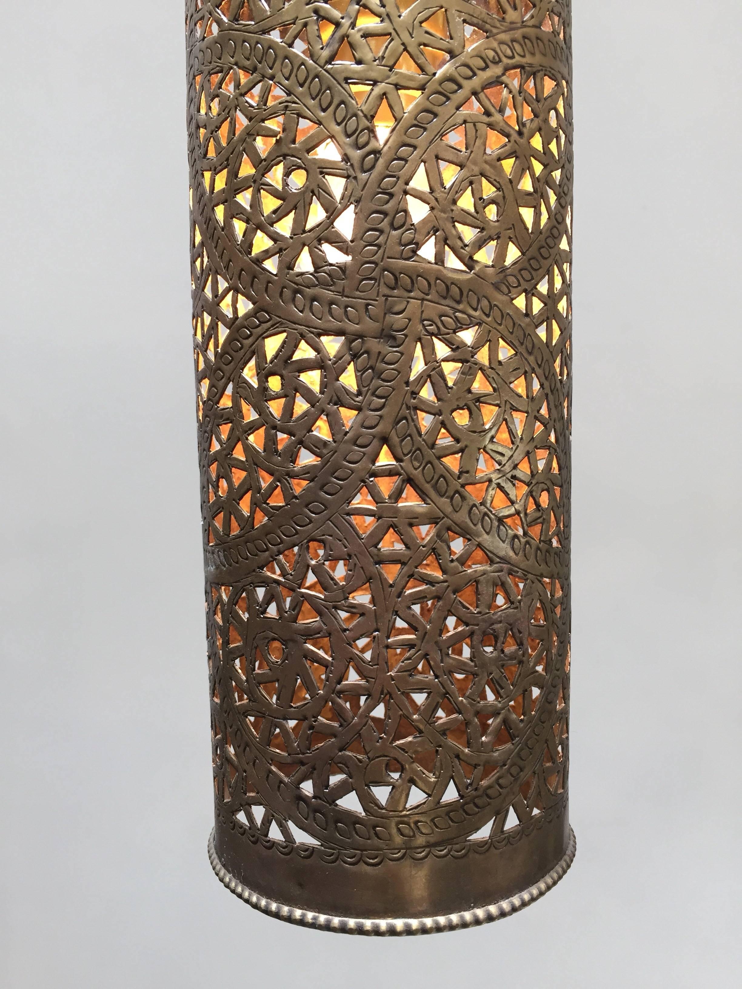 Pair of Moroccan brass pendants lights in cylinder form.
Nice handcrafted lanterns with Moorish geometric brass filigree openwork hammered and pierced design.
Rewired for one light bulb.
Total height with chain and ceiling canopy: 33 inches,